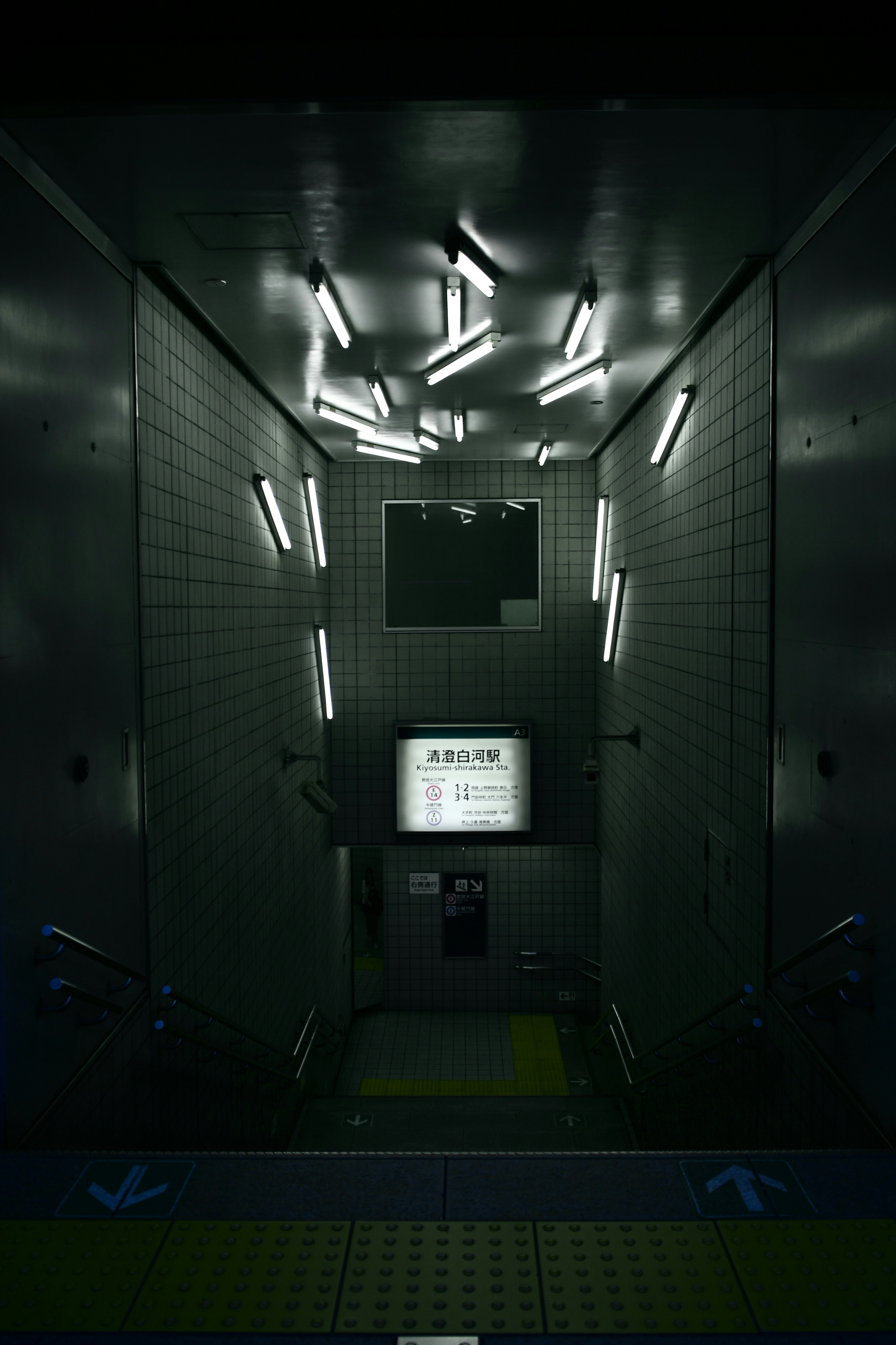 Image of a dark corridor with flickering white fluorescent lights at the entrance