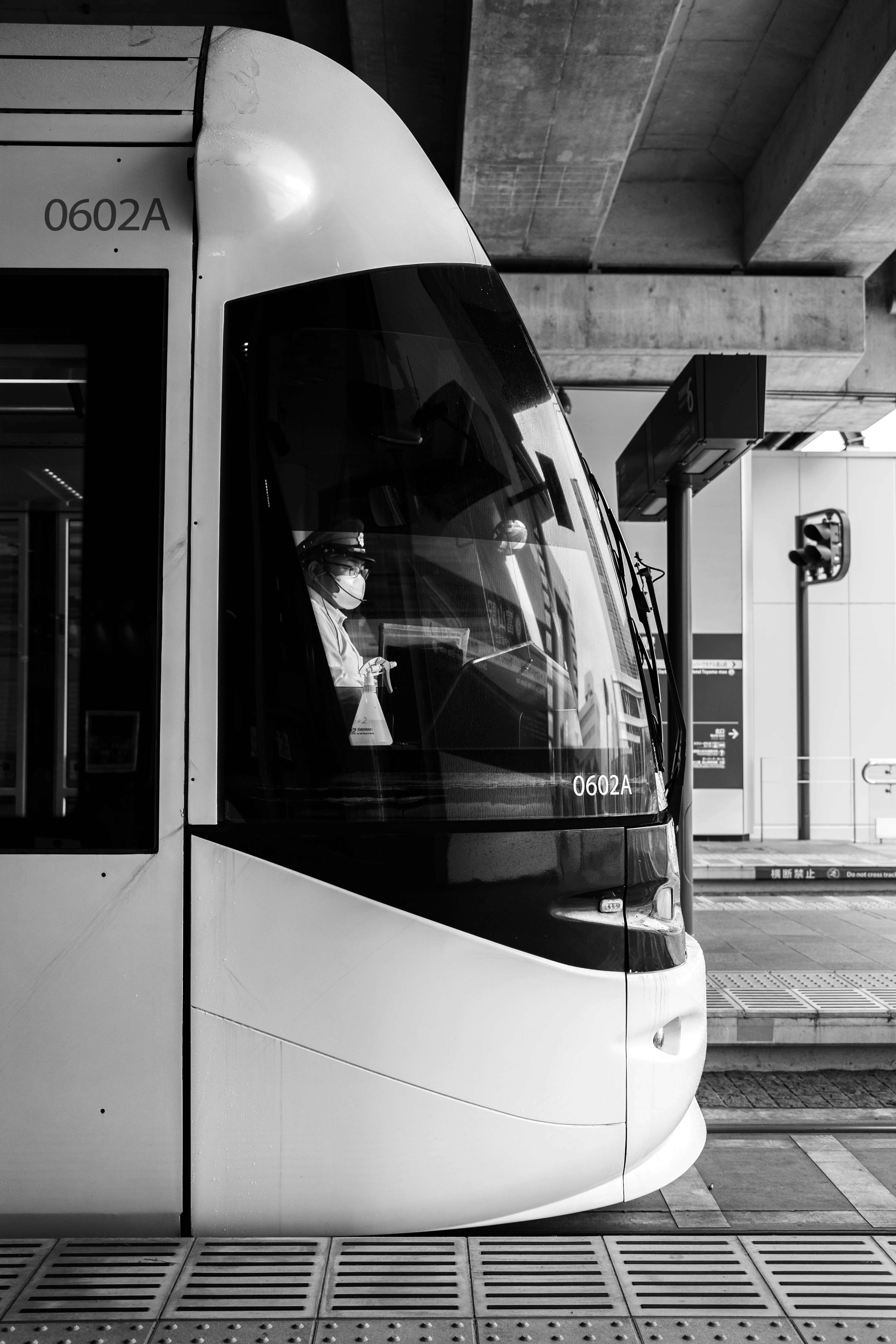 Black and white tram side view at a station