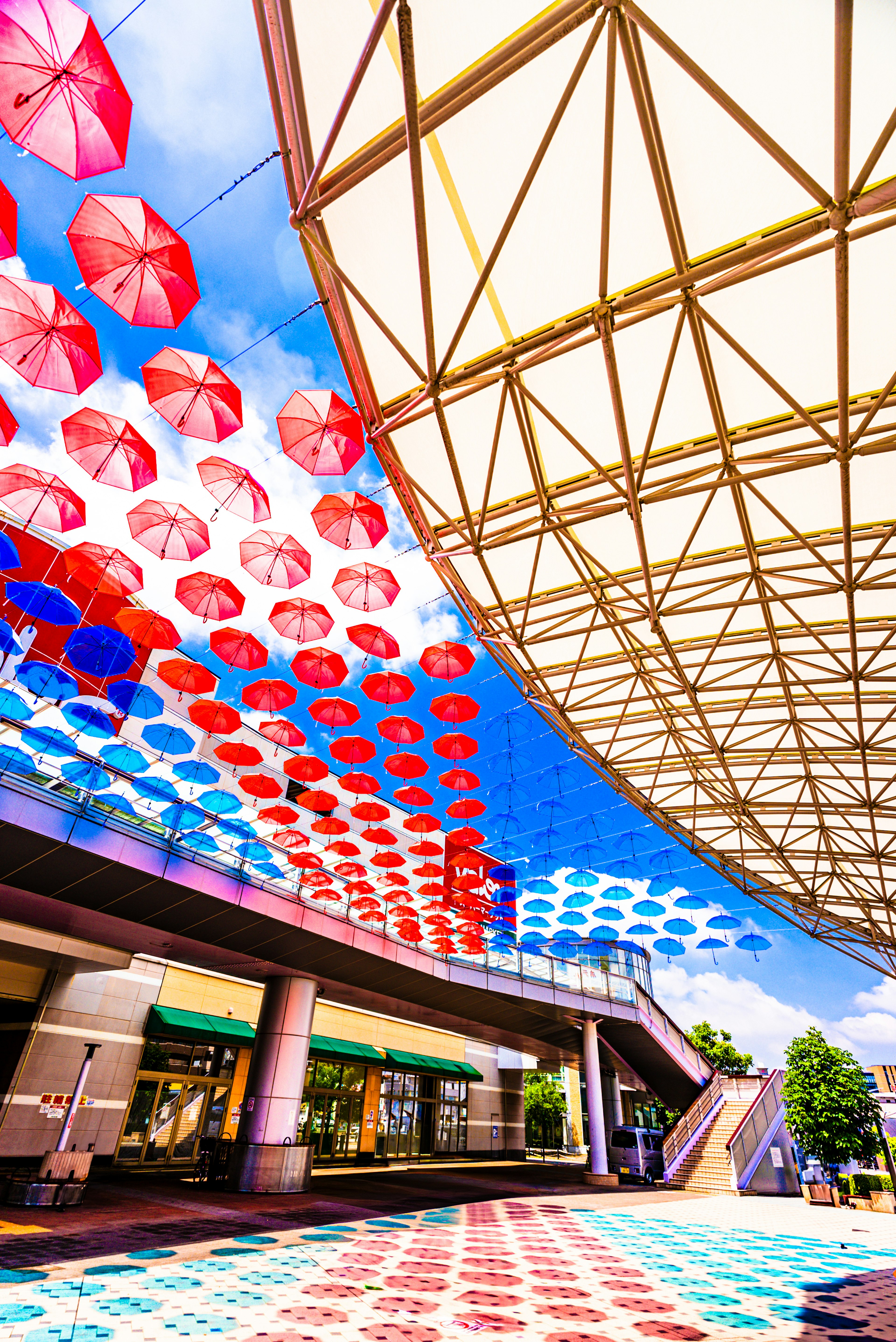 Espace extérieur magnifique avec des parapluies rouges et bleus suspendus au-dessus