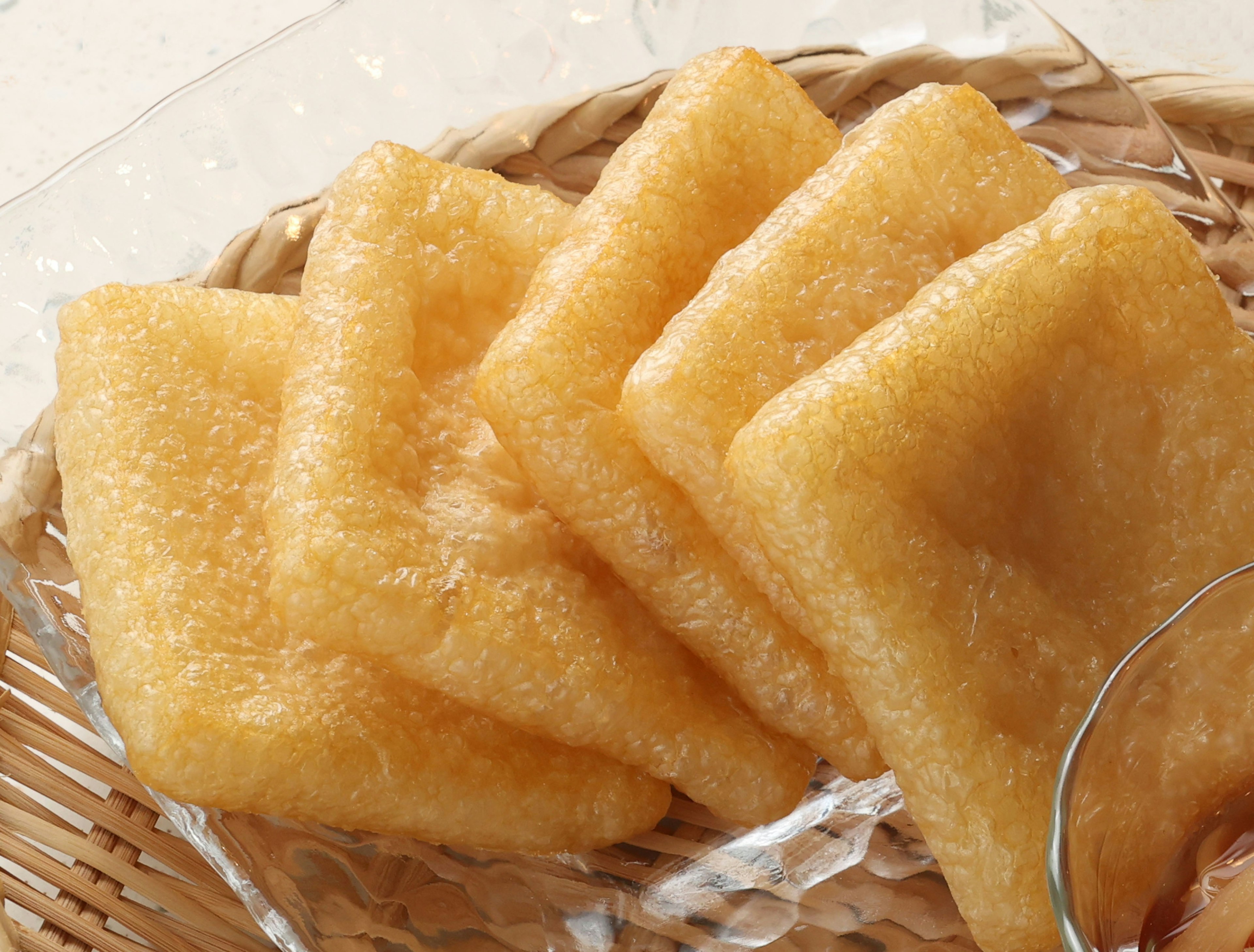 Kue beras goreng berwarna emas disusun dalam keranjang