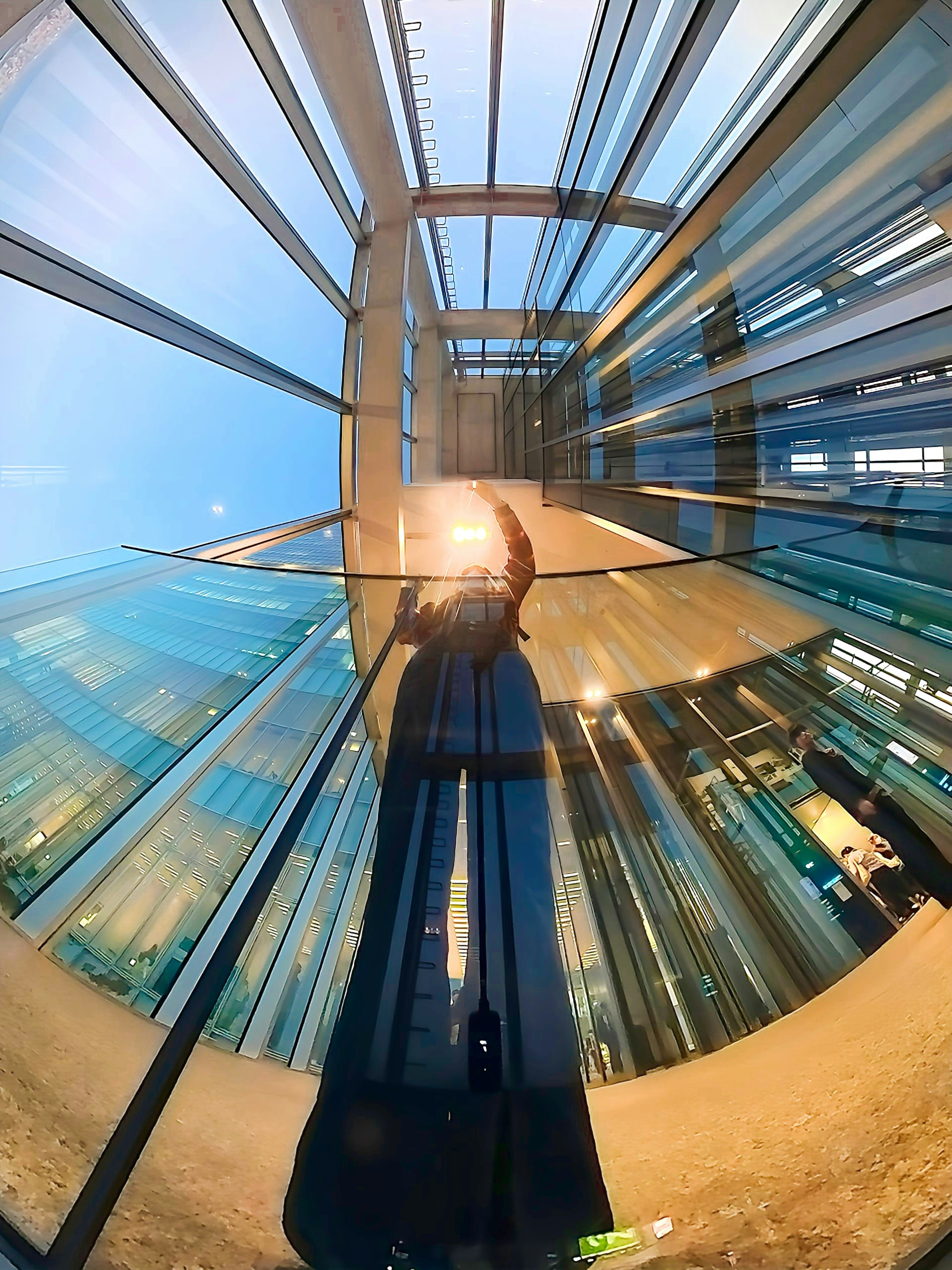 A person casting their shadow inside a glass building