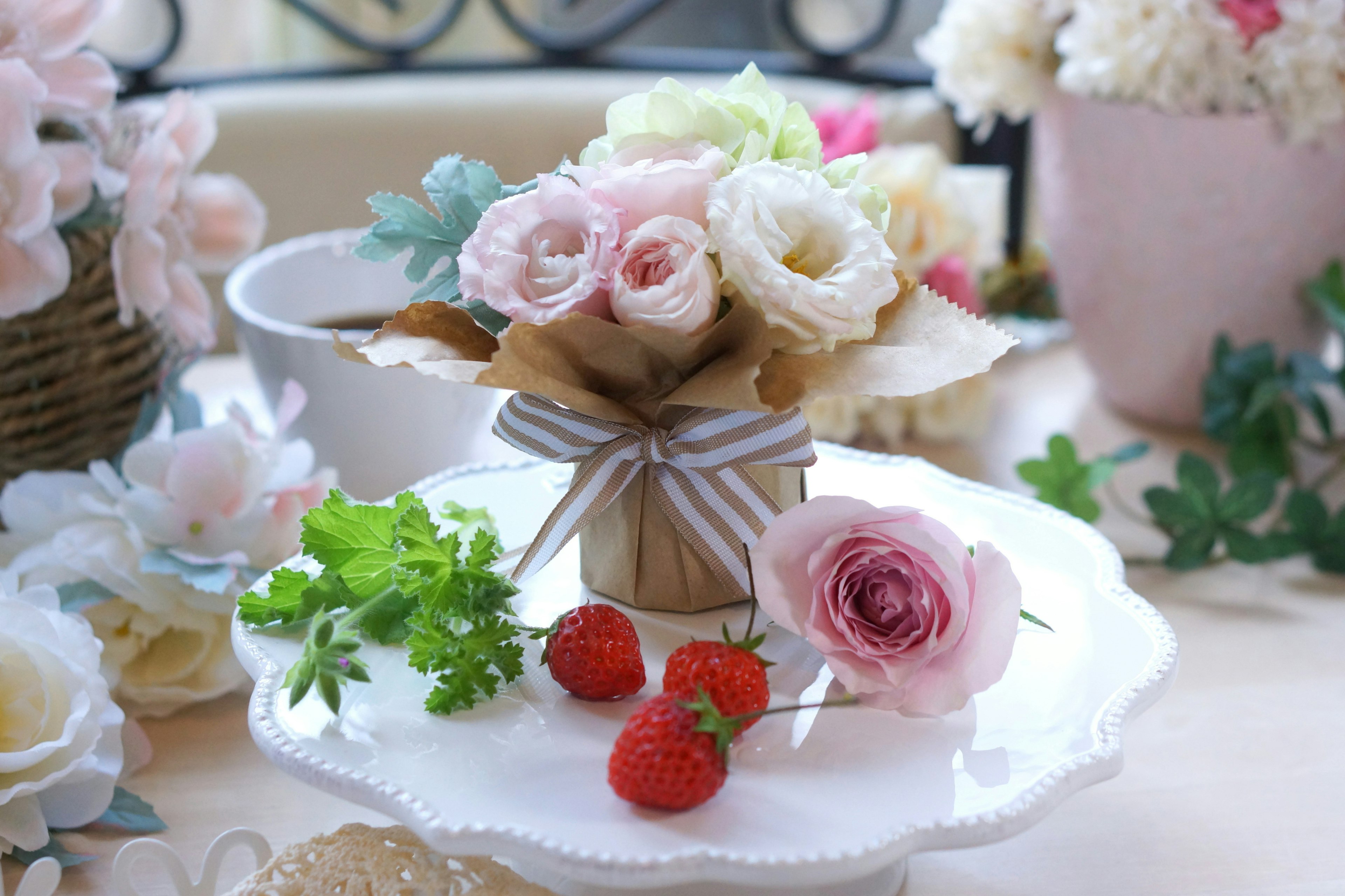 A table setting featuring a bouquet of pink and white roses