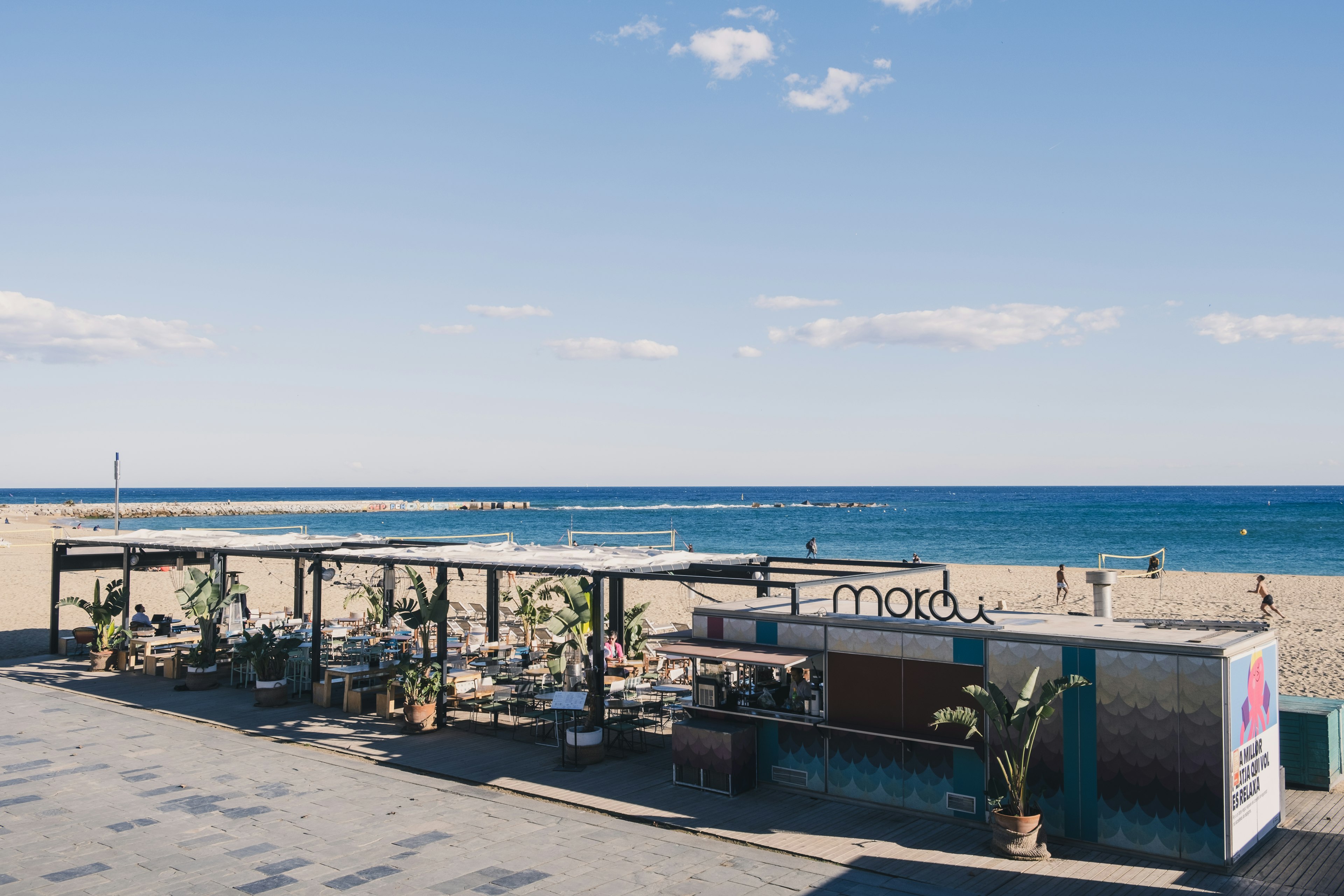 Freiluftcafé in der Nähe des Strandes mit blauem Ozean im Hintergrund