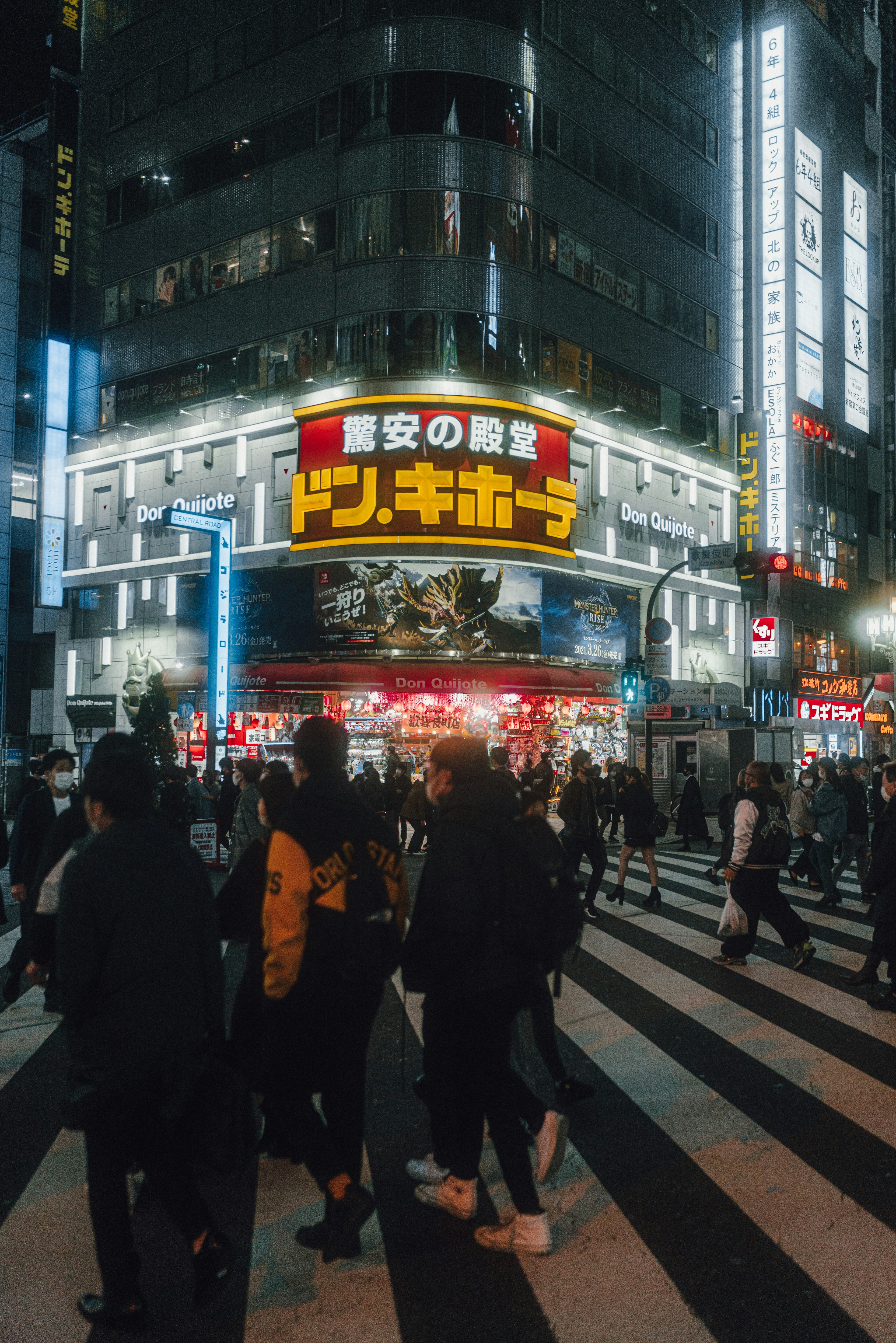 Multitud en el cruce de Shibuya con letrero brillante por la noche