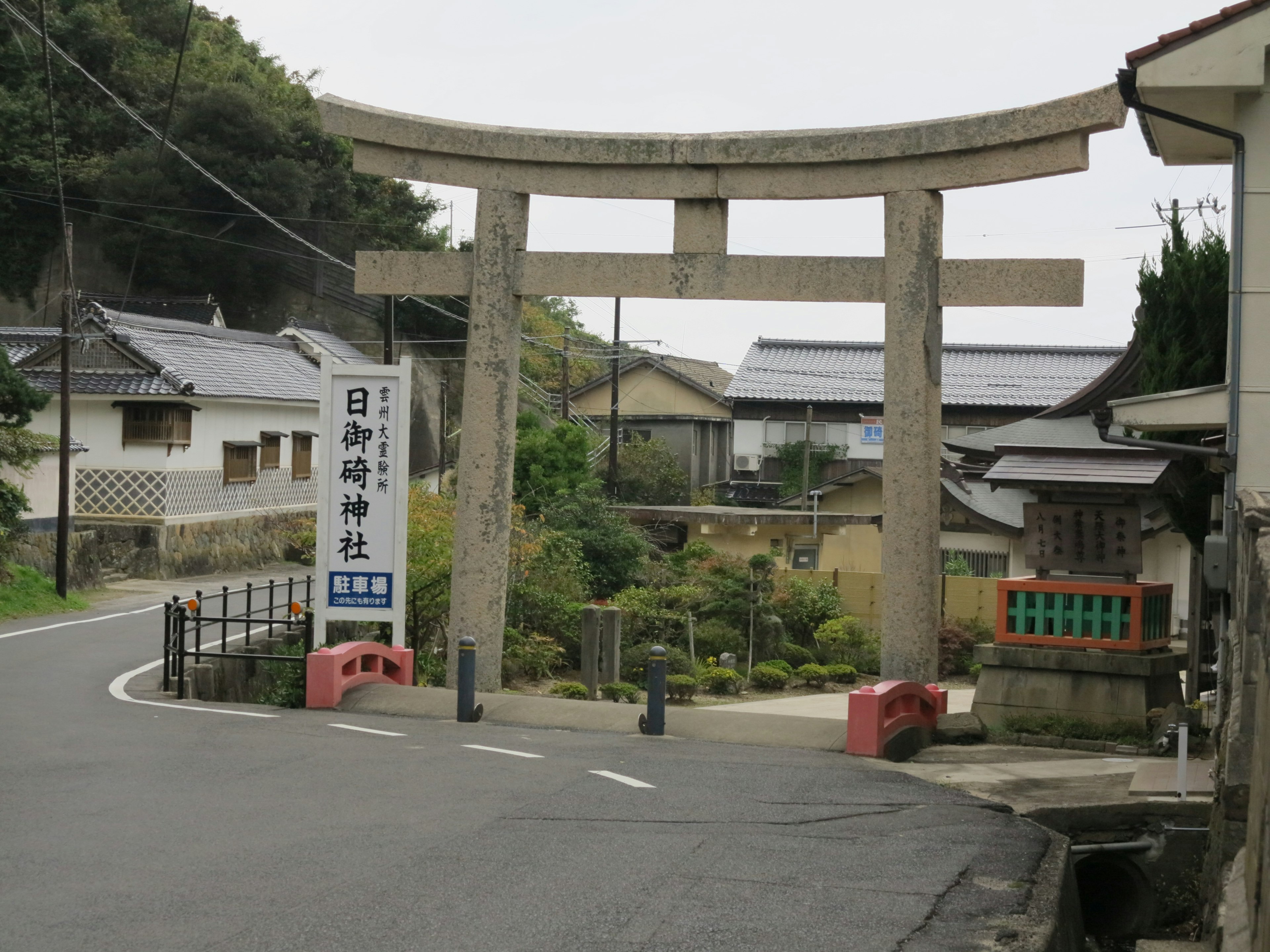 Portail torii en pierre à l'entrée d'un sanctuaire japonais avec le paysage environnant