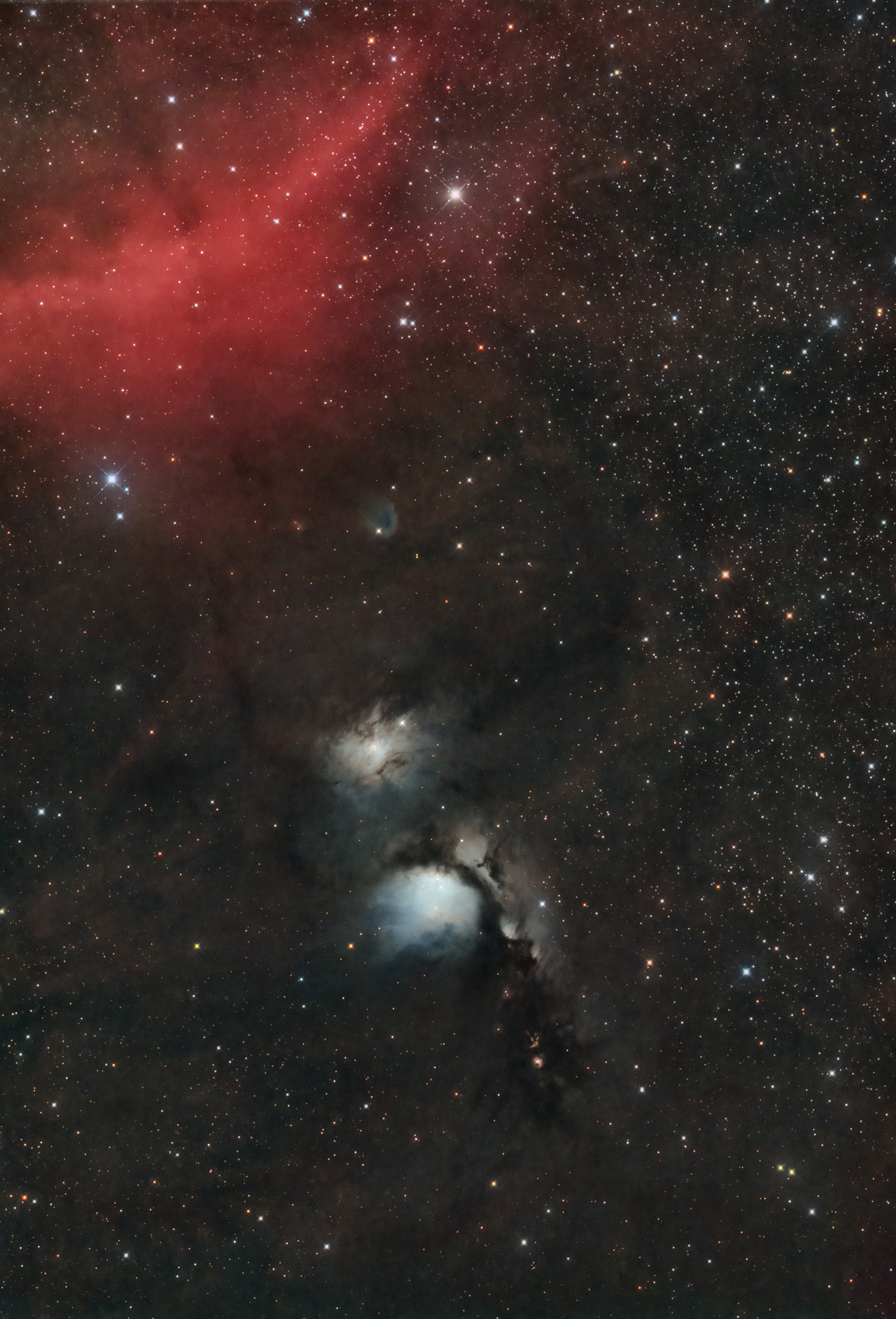 Escena cósmica con nebulosa roja y nube estelar azul en un cielo estrellado