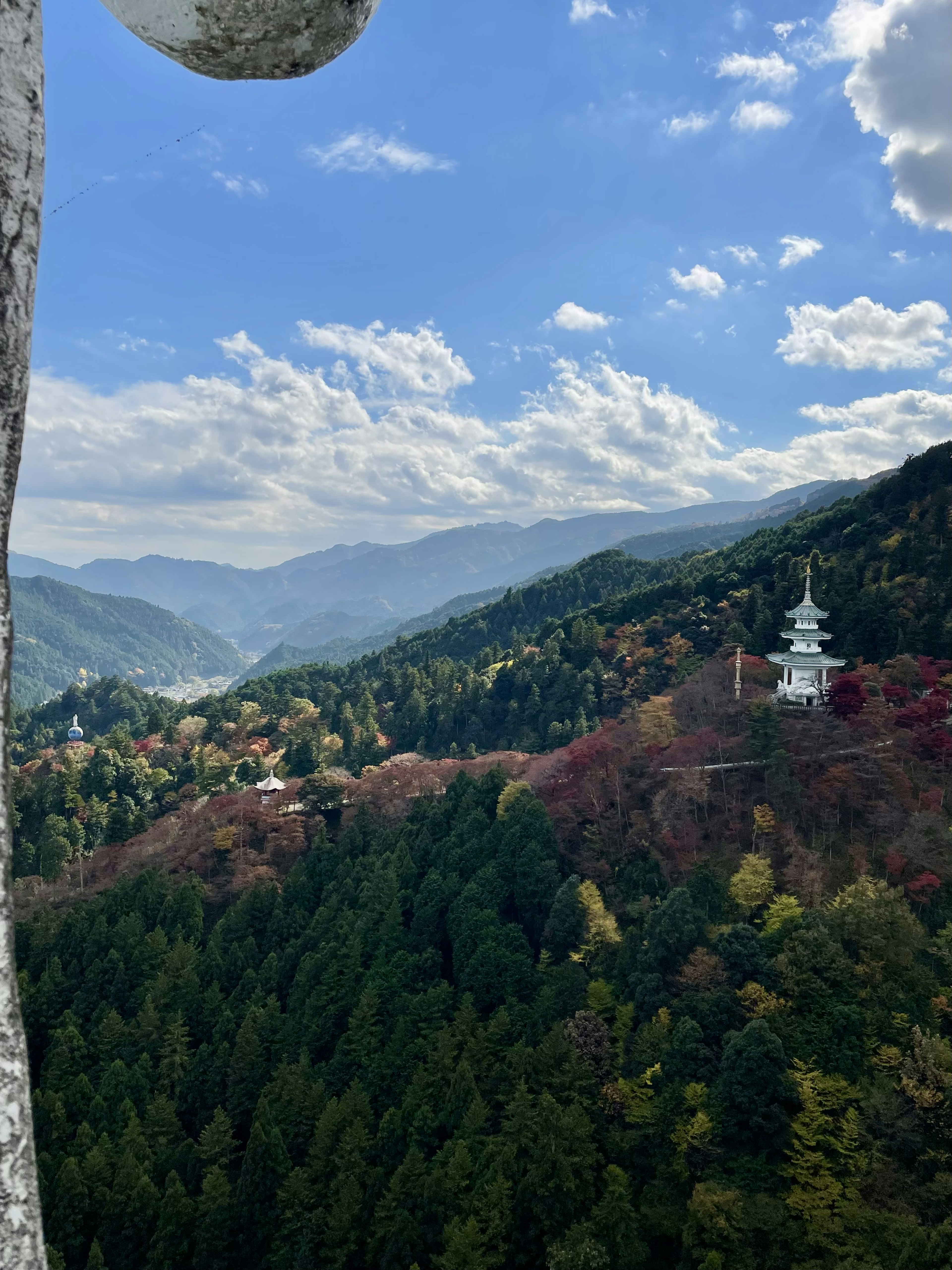 Vue panoramique sur des montagnes avec un feuillage d'automne et une pagode blanche