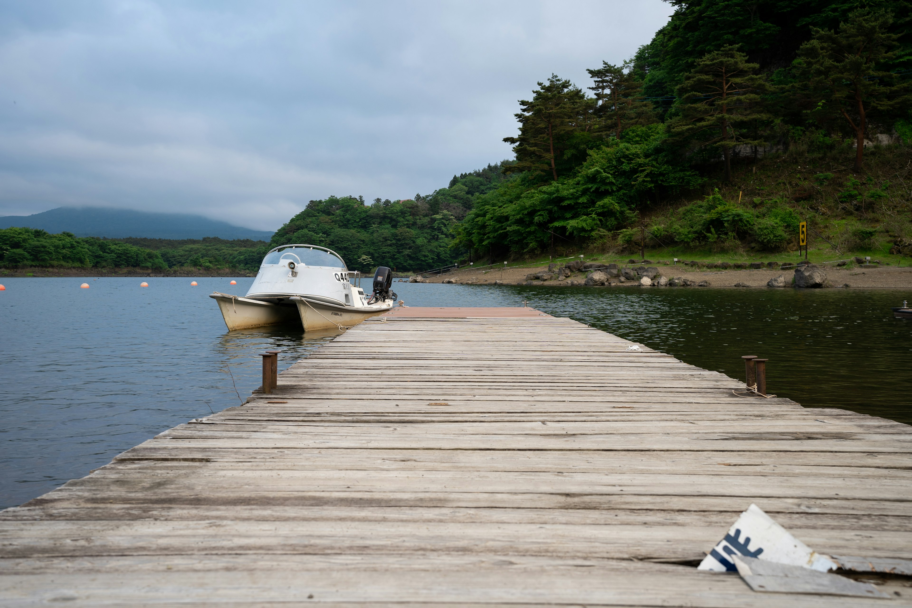 Vista escénica de un bote en un lago tranquilo con un muelle de madera