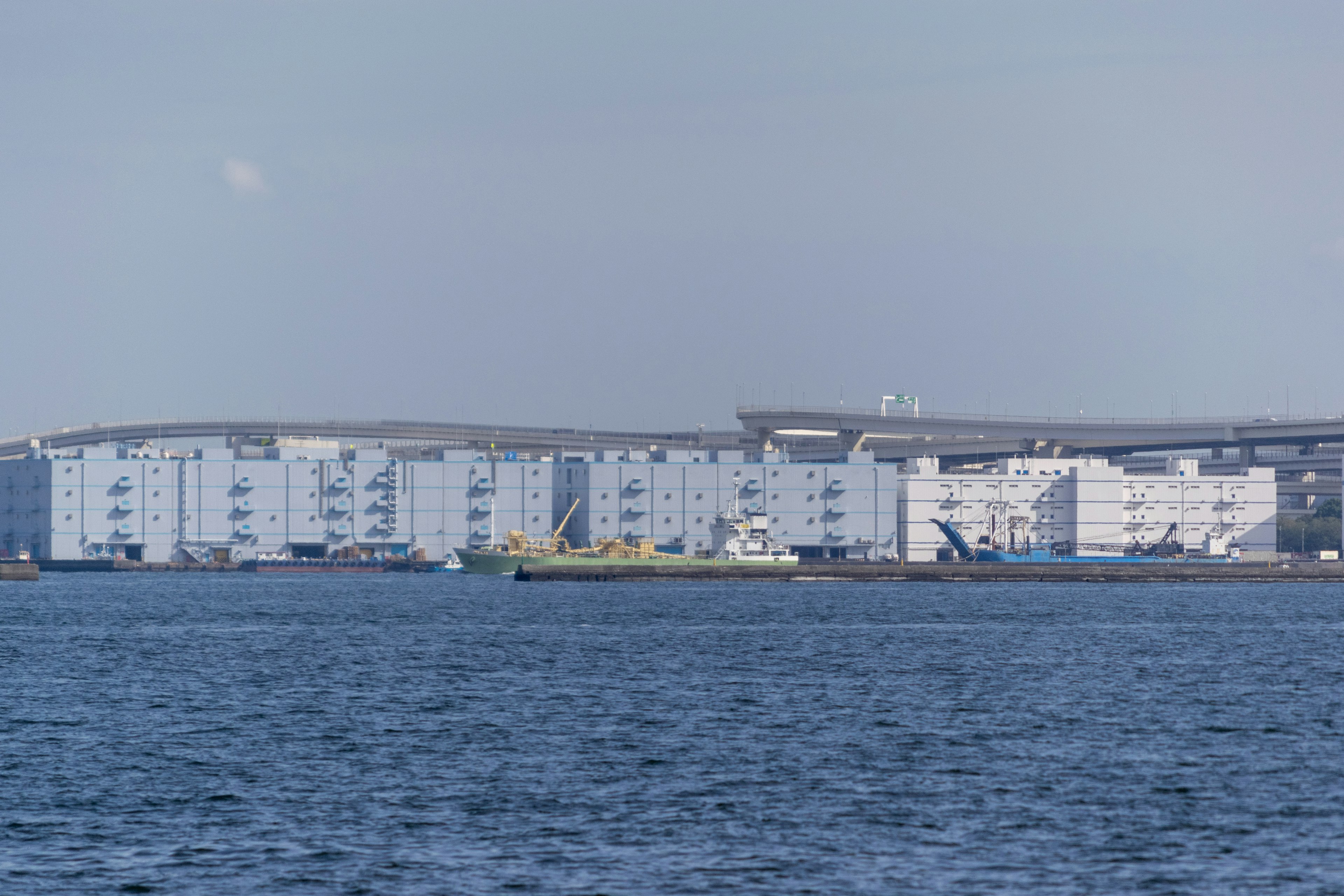 Row of white buildings along the waterfront with a small boat