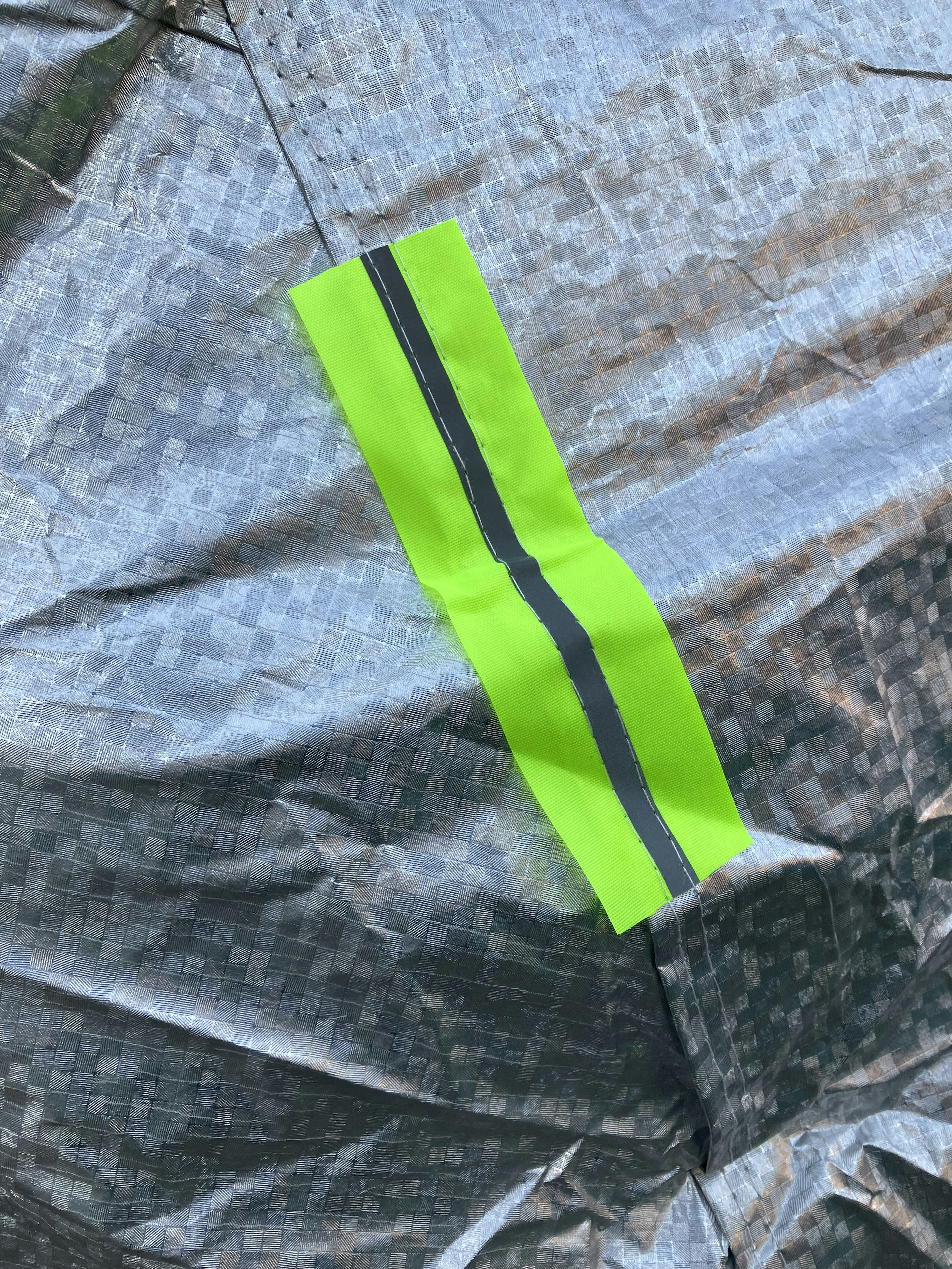 Bright green reflective tape attached to a silver fabric