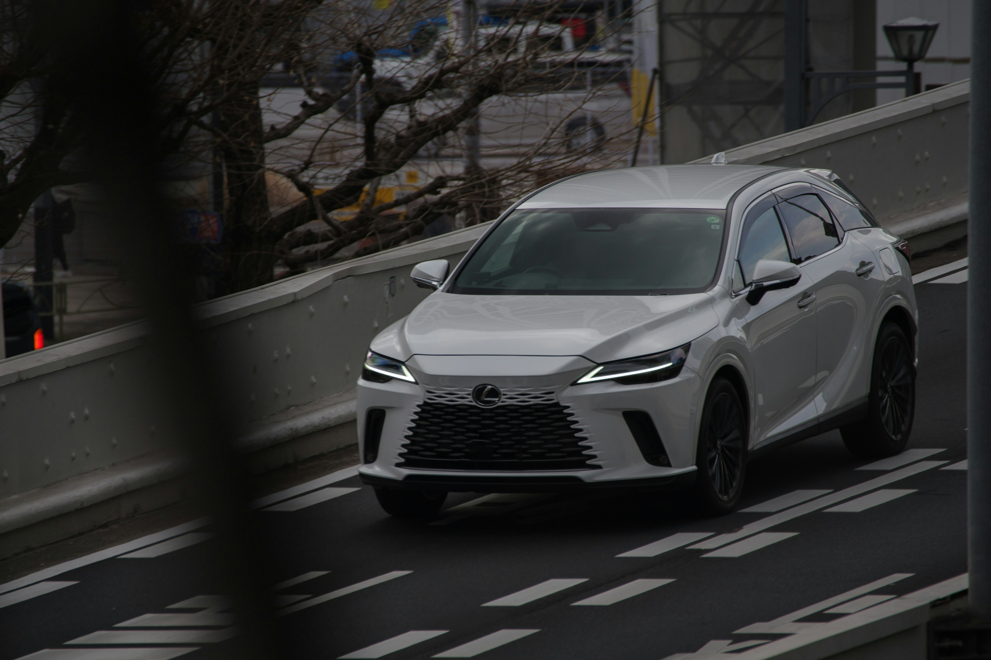 A white Lexus SUV driving on a road