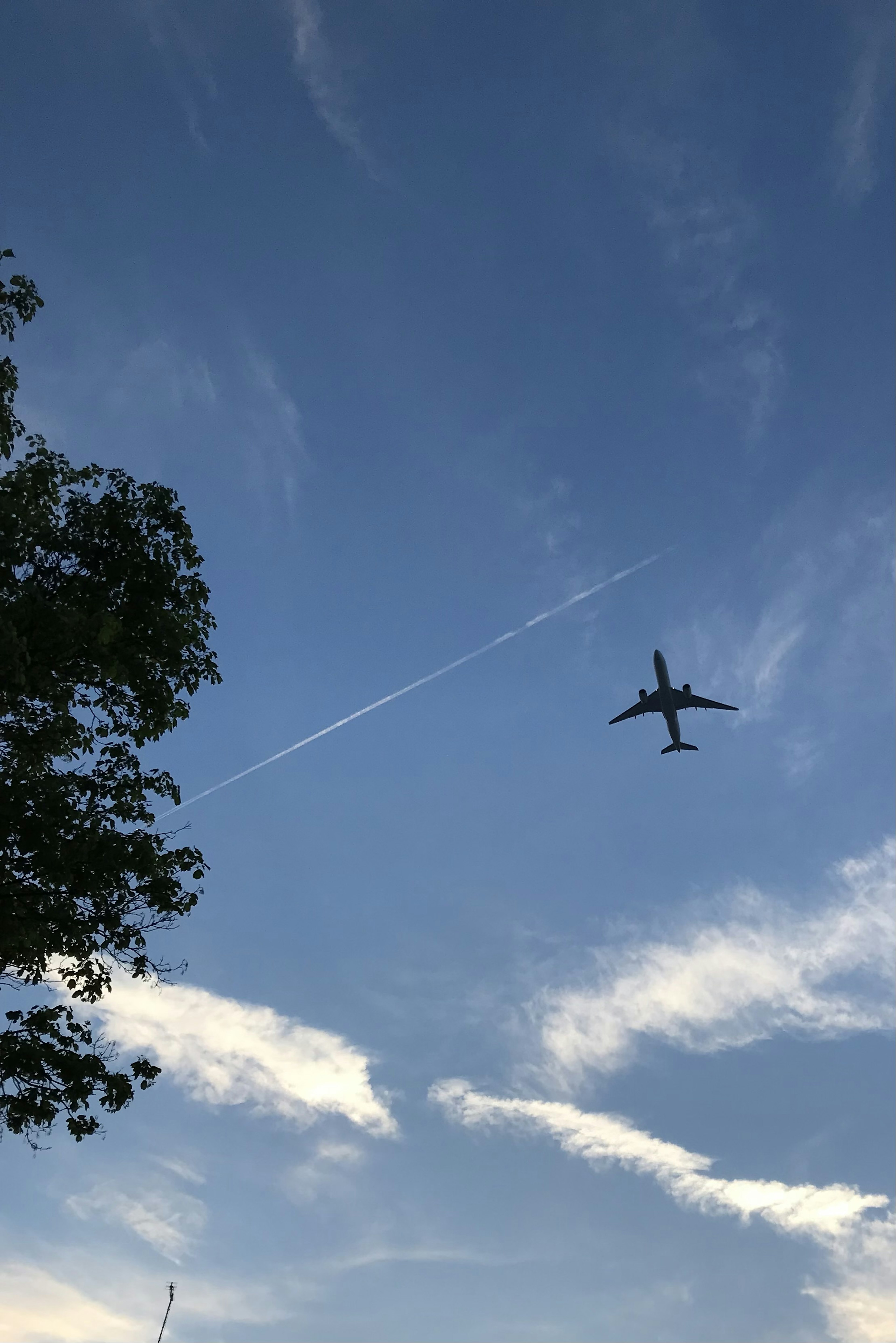 Aereo che vola nel cielo blu con nuvole bianche