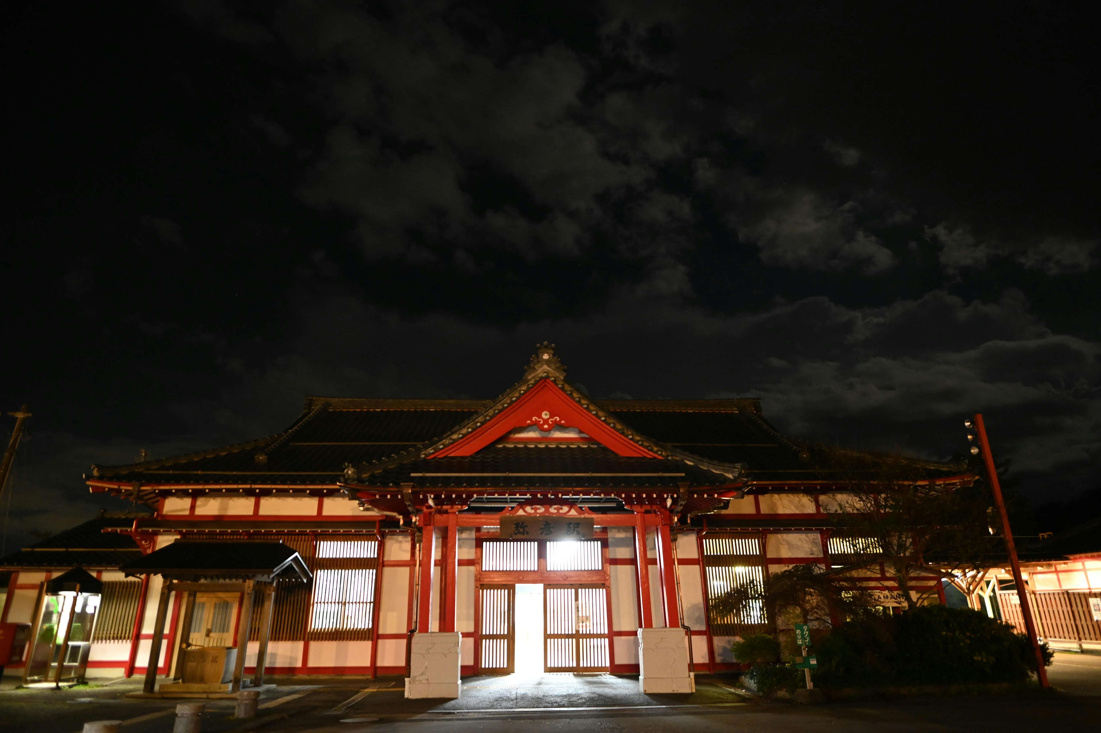 Edificio japonés tradicional con techo rojo iluminado por la noche