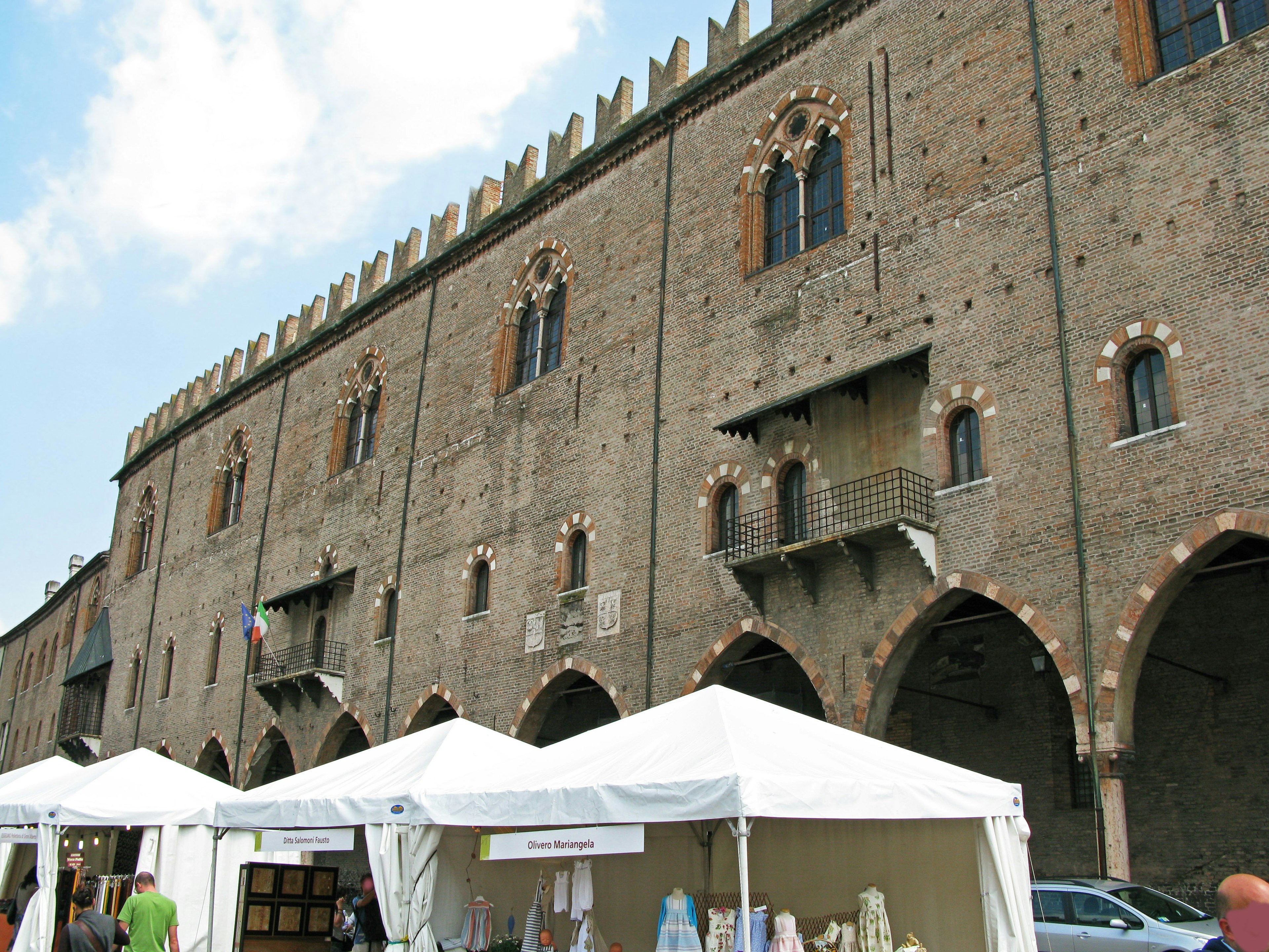 Edificio storico con bancarelle di mercato in primo piano