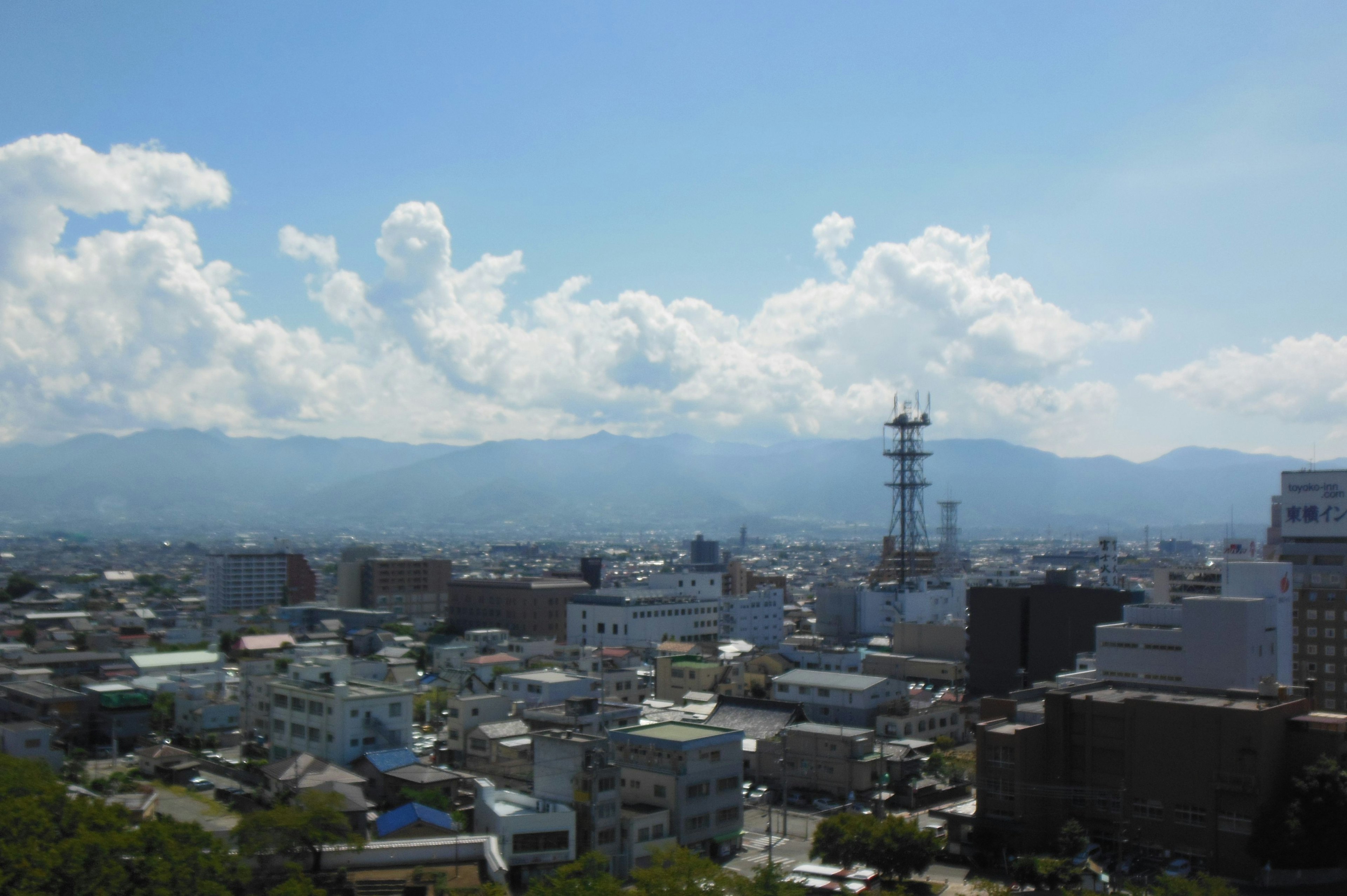 城市景觀，藍天和雲彩，背景是山脈