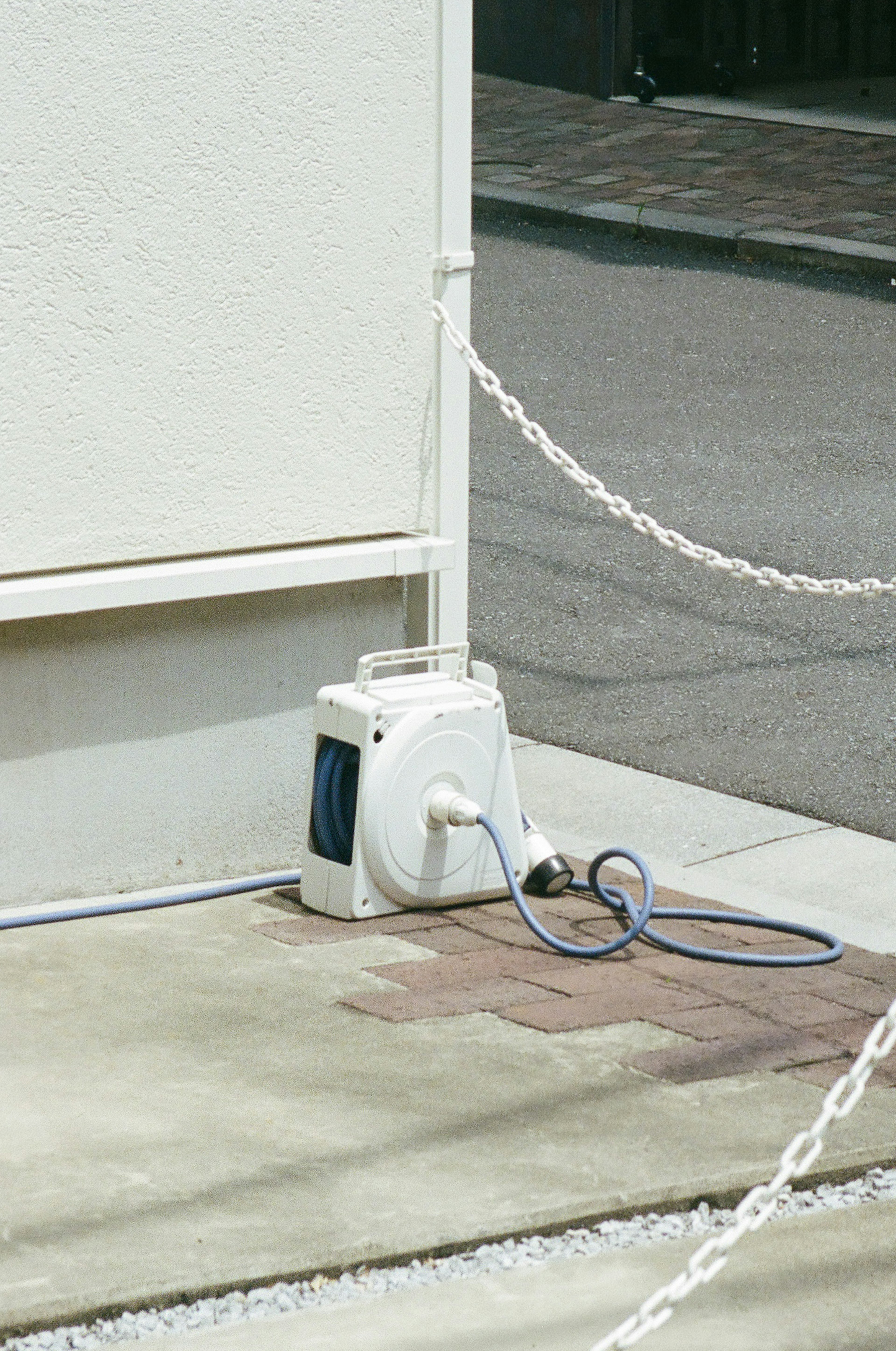 Un pequeño dispositivo eléctrico blanco con una manguera azul cerca de una pared blanca