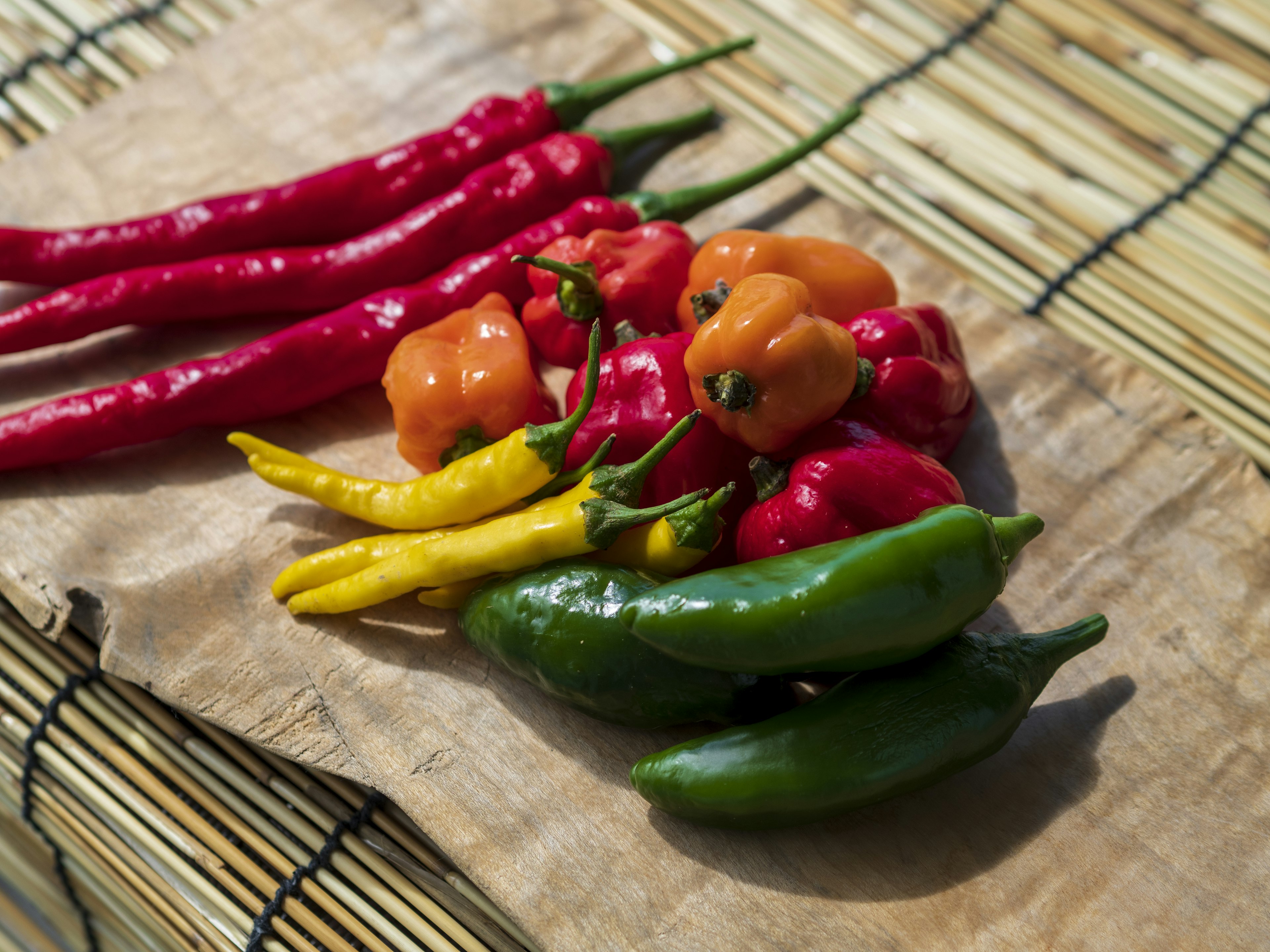 Colorful chili peppers arranged on a wooden surface