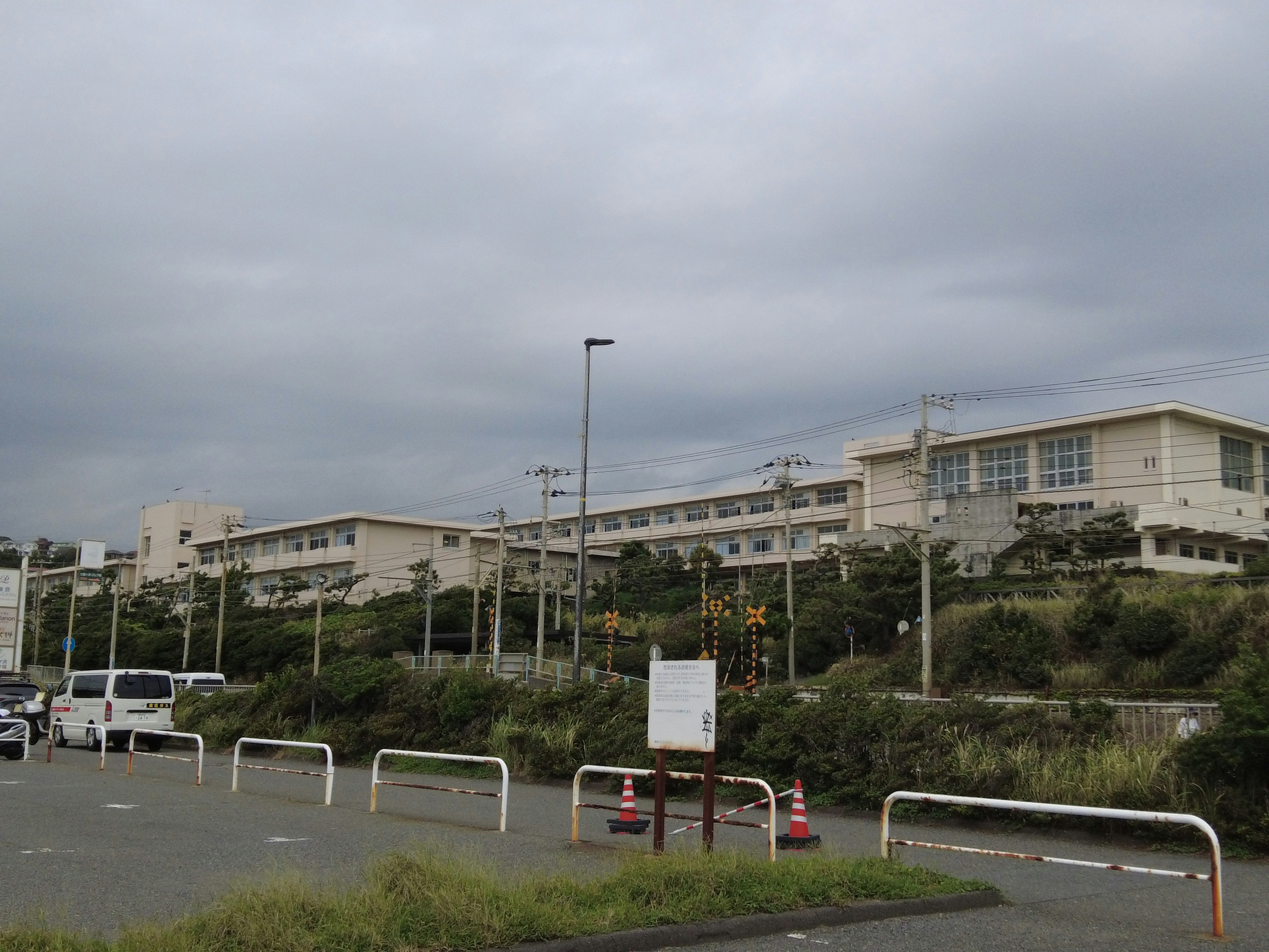 Exterior view of a school building with a white facade under a cloudy sky