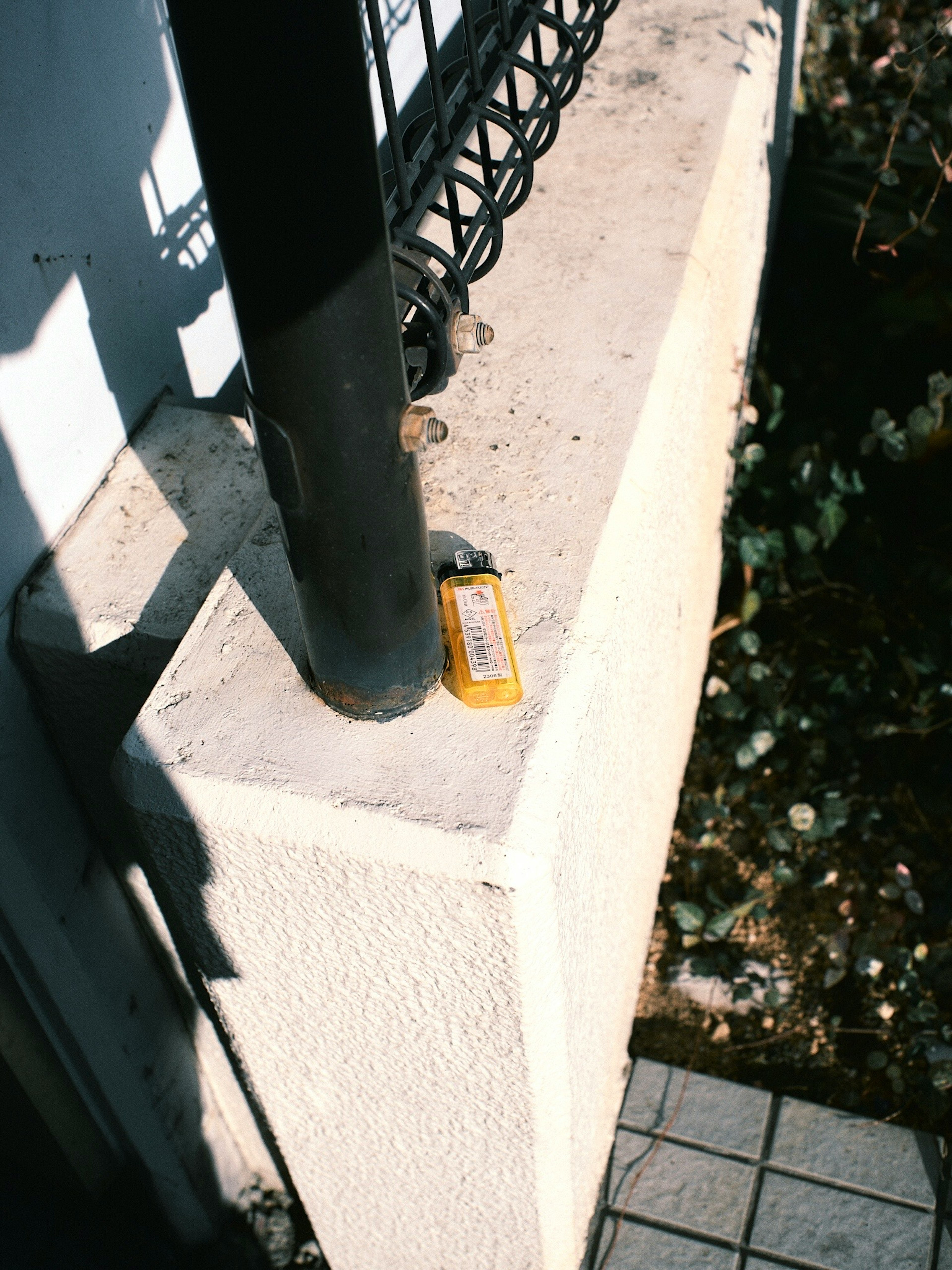 Un objet jaune placé près d'un pilier en béton