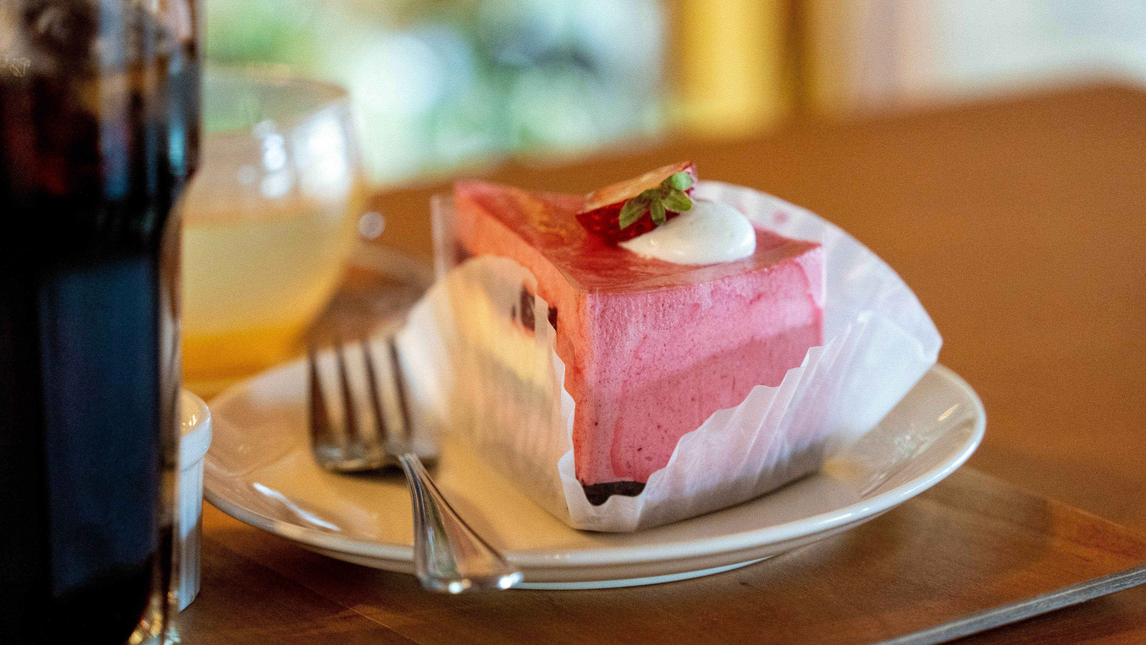 접시에 담긴 맛있는 수박 케이크 위에 크림과 민트 잎이 얹혀 있다