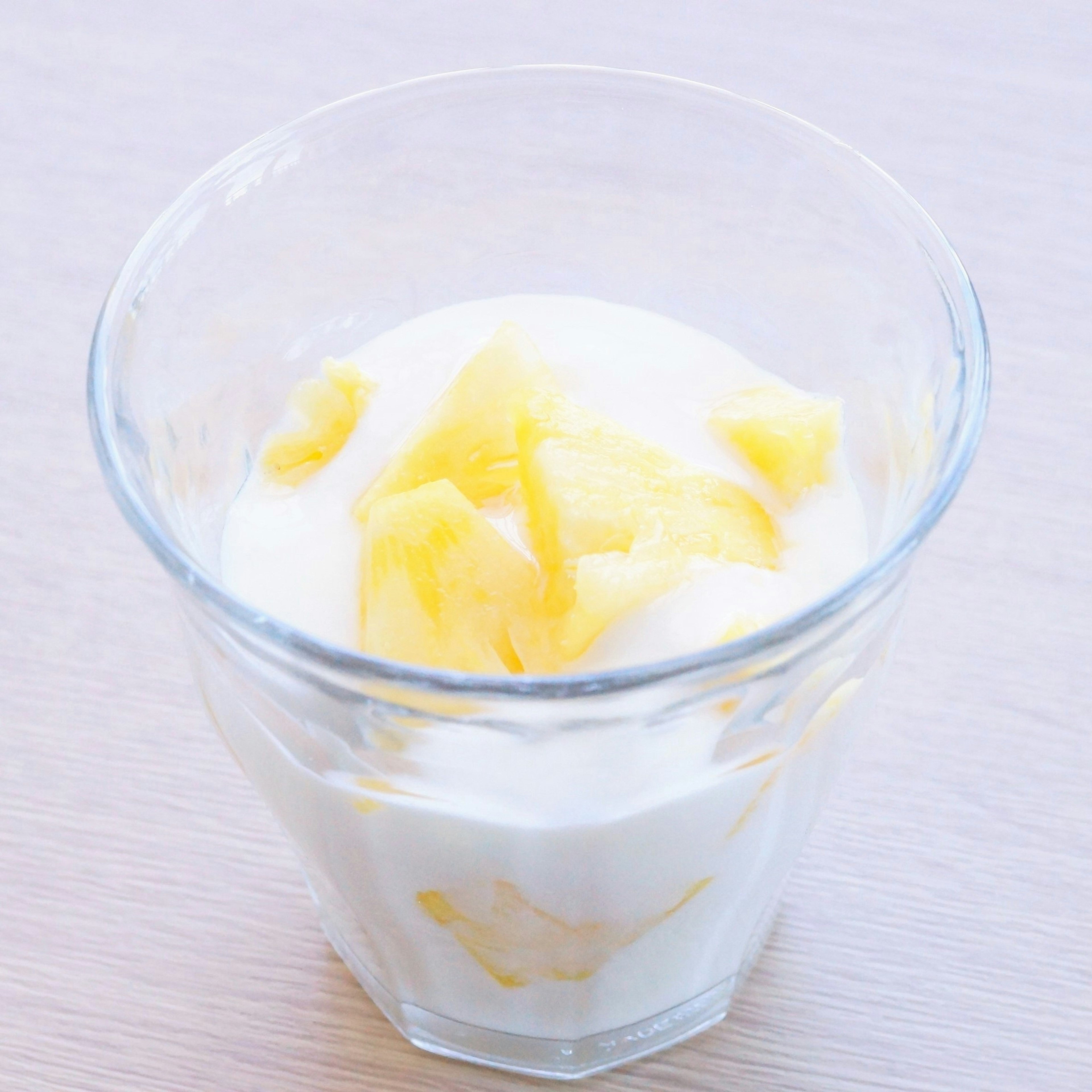 Yogurt topped with mango pieces in a clear glass