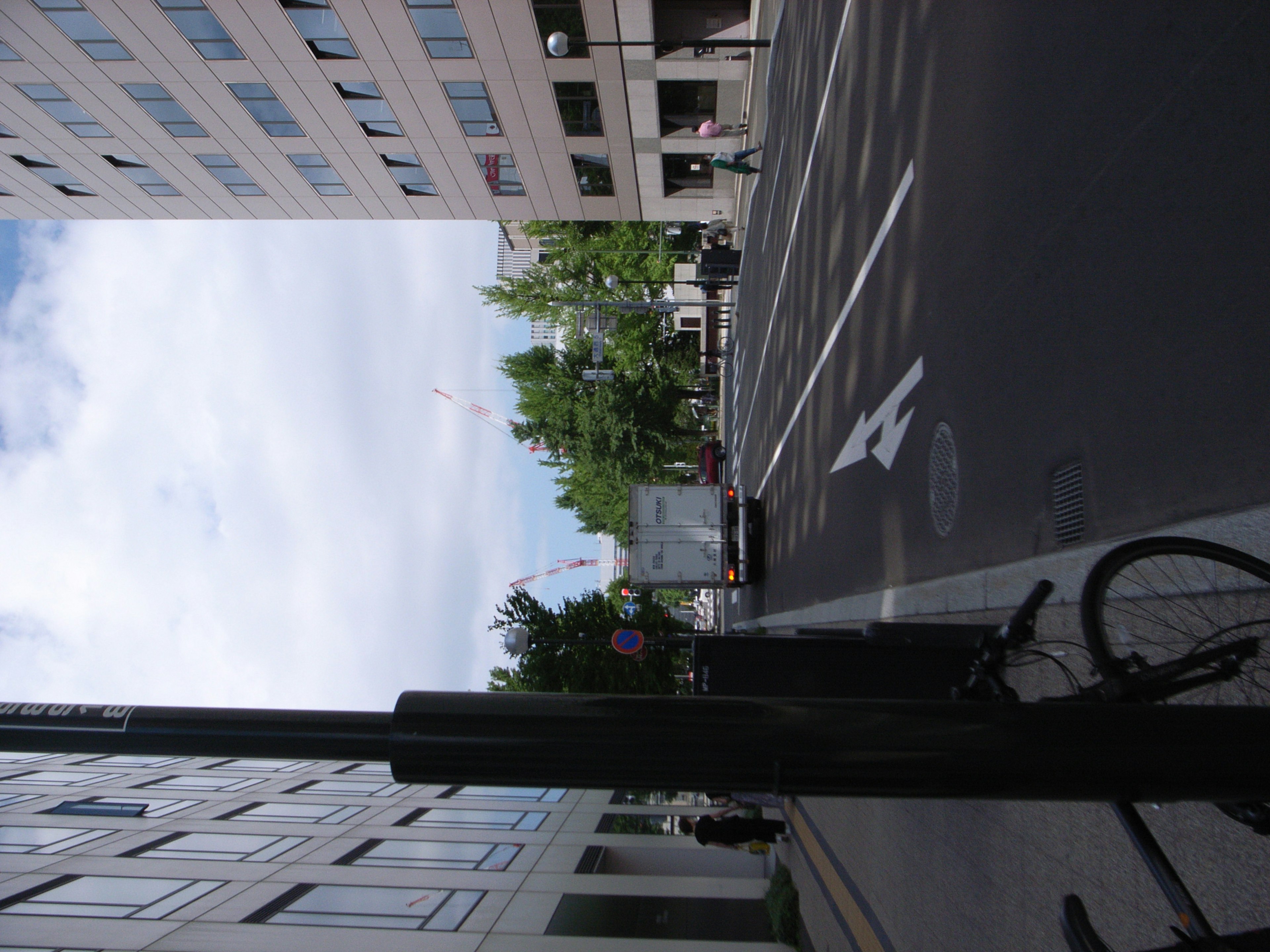 都市の風景に自転車のスタンドと街路樹が見える