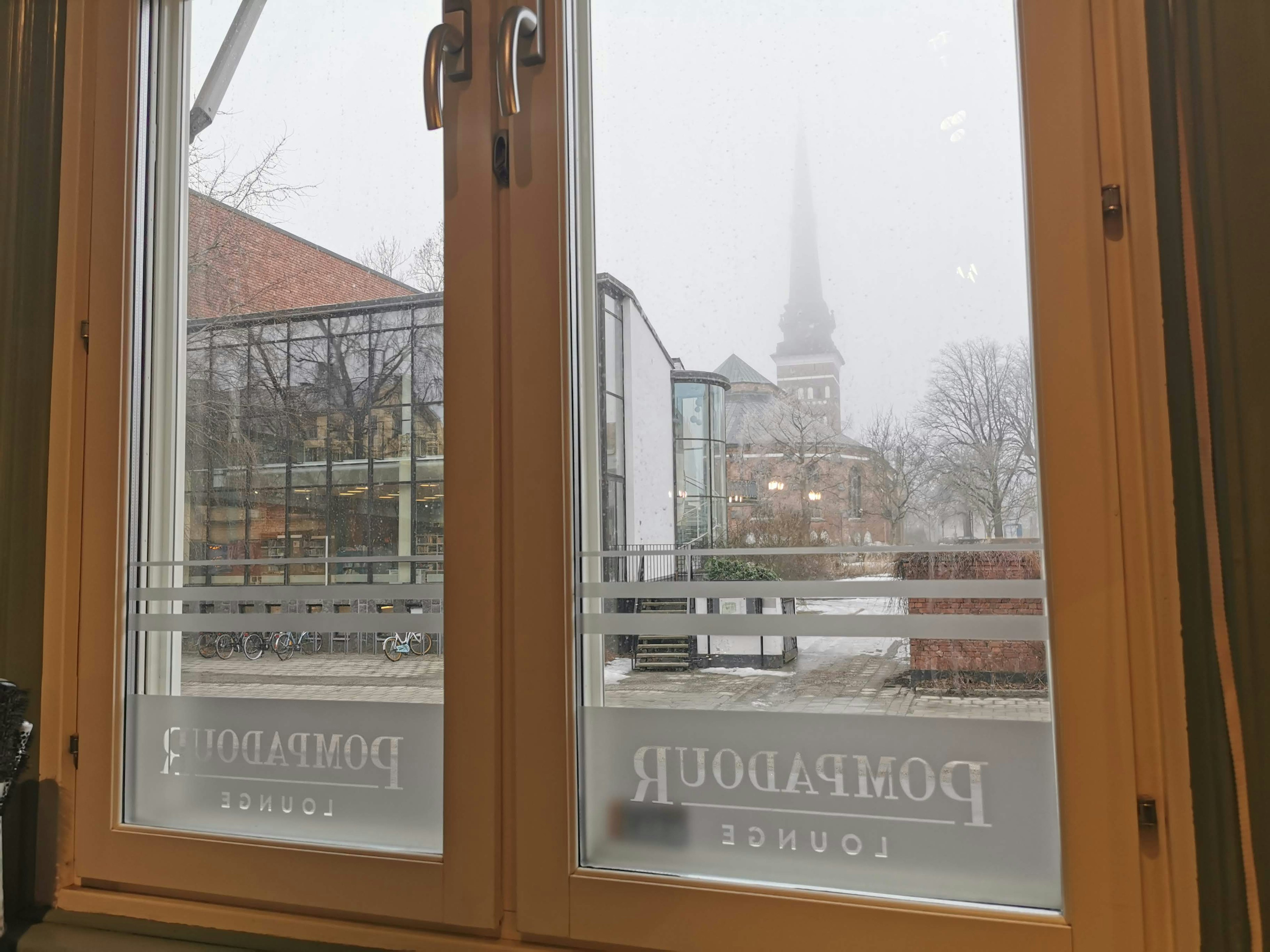 Foggy view through a window featuring a church spire