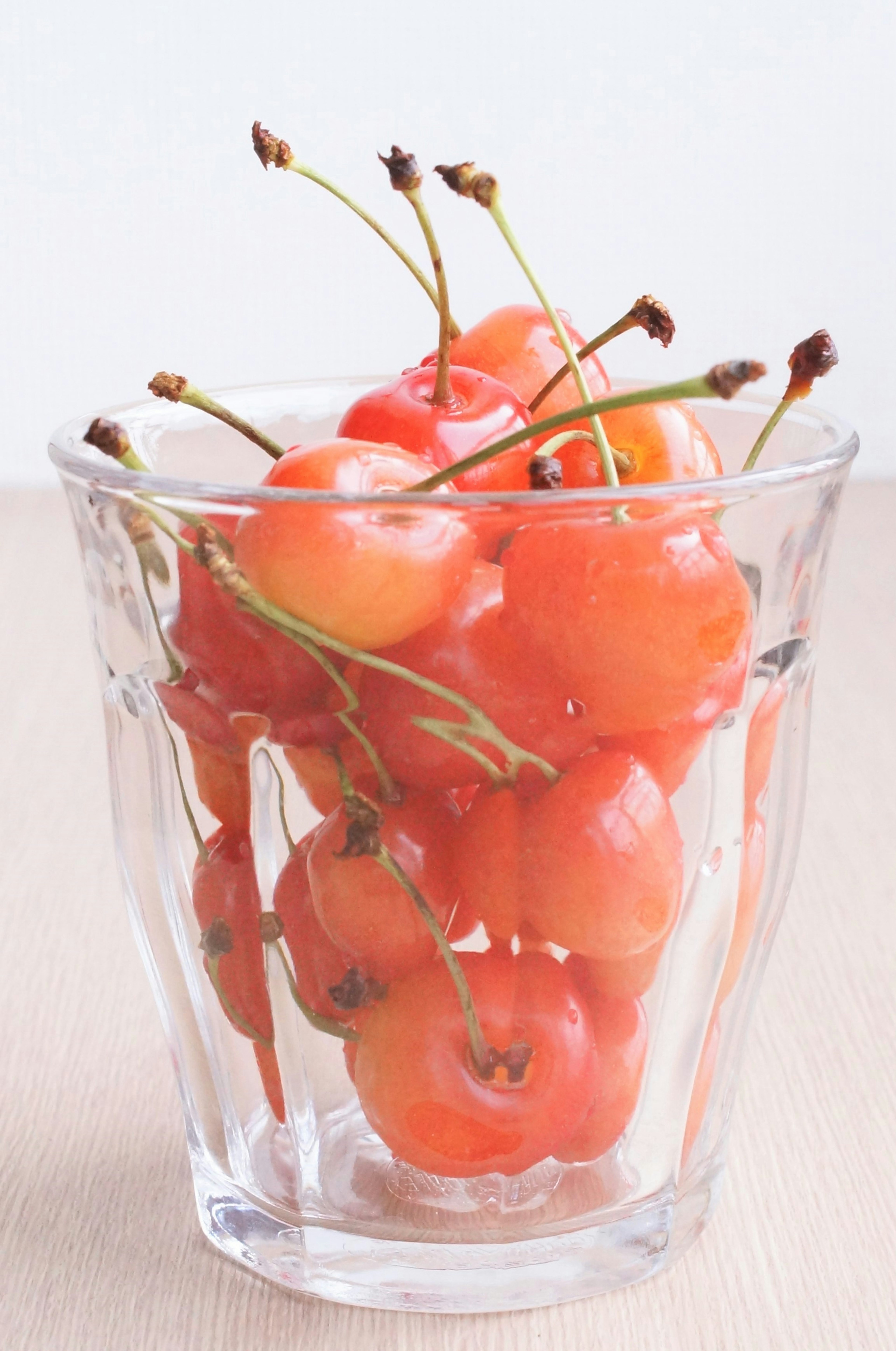 Un manojo de frutas rojas en un vaso transparente