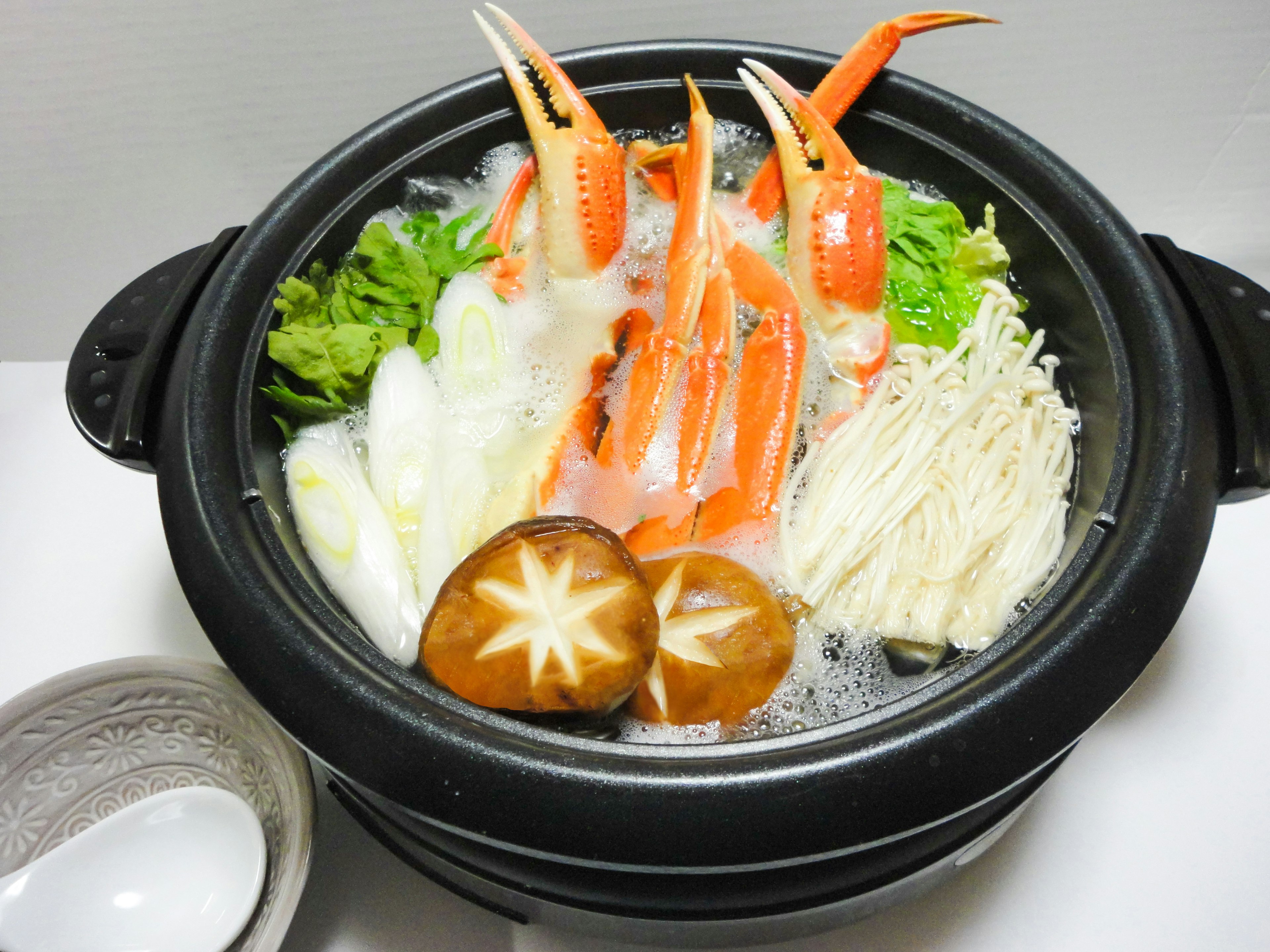 A hot pot filled with crab and assorted vegetables