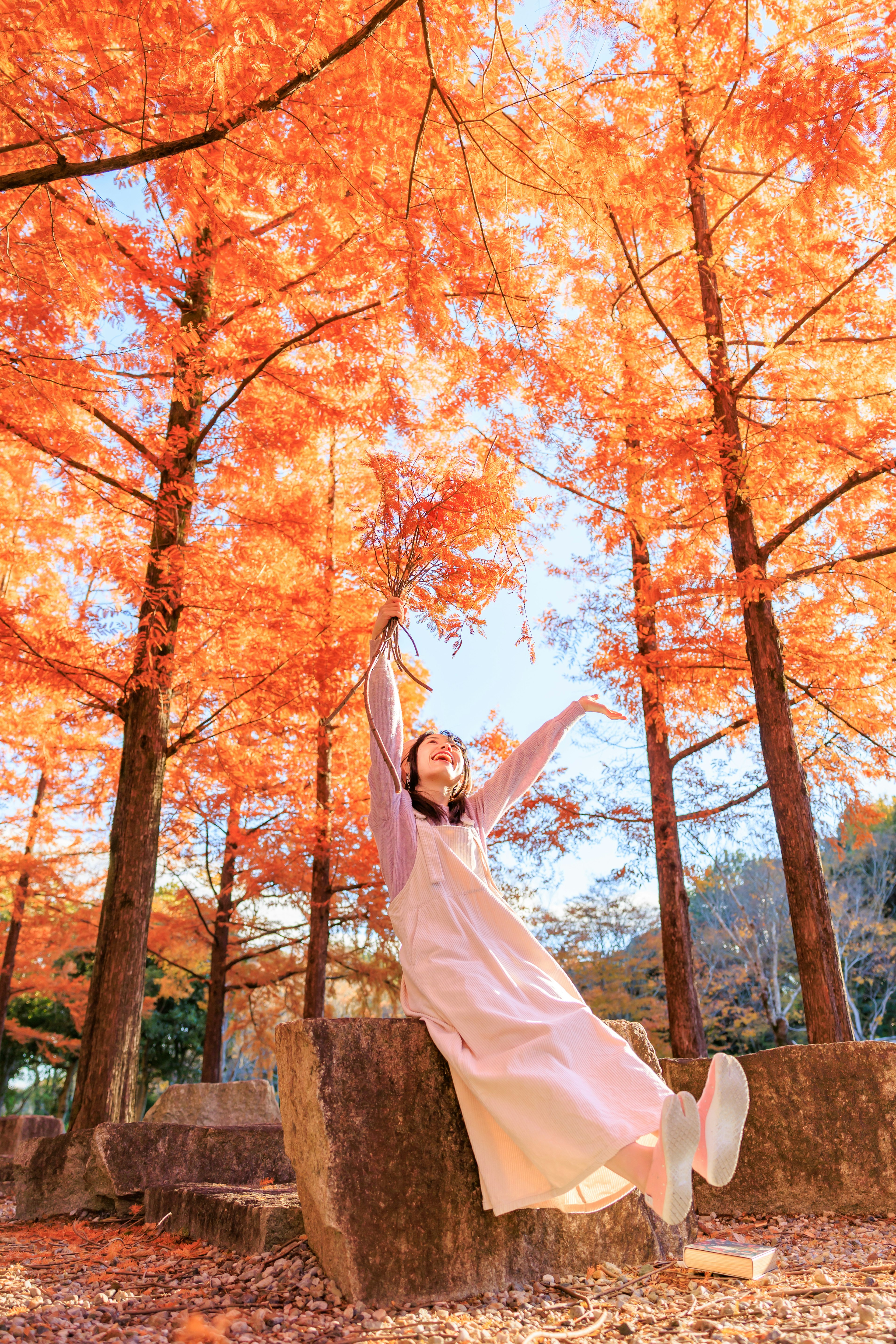 秋の紅葉の中でポーズを取る女性