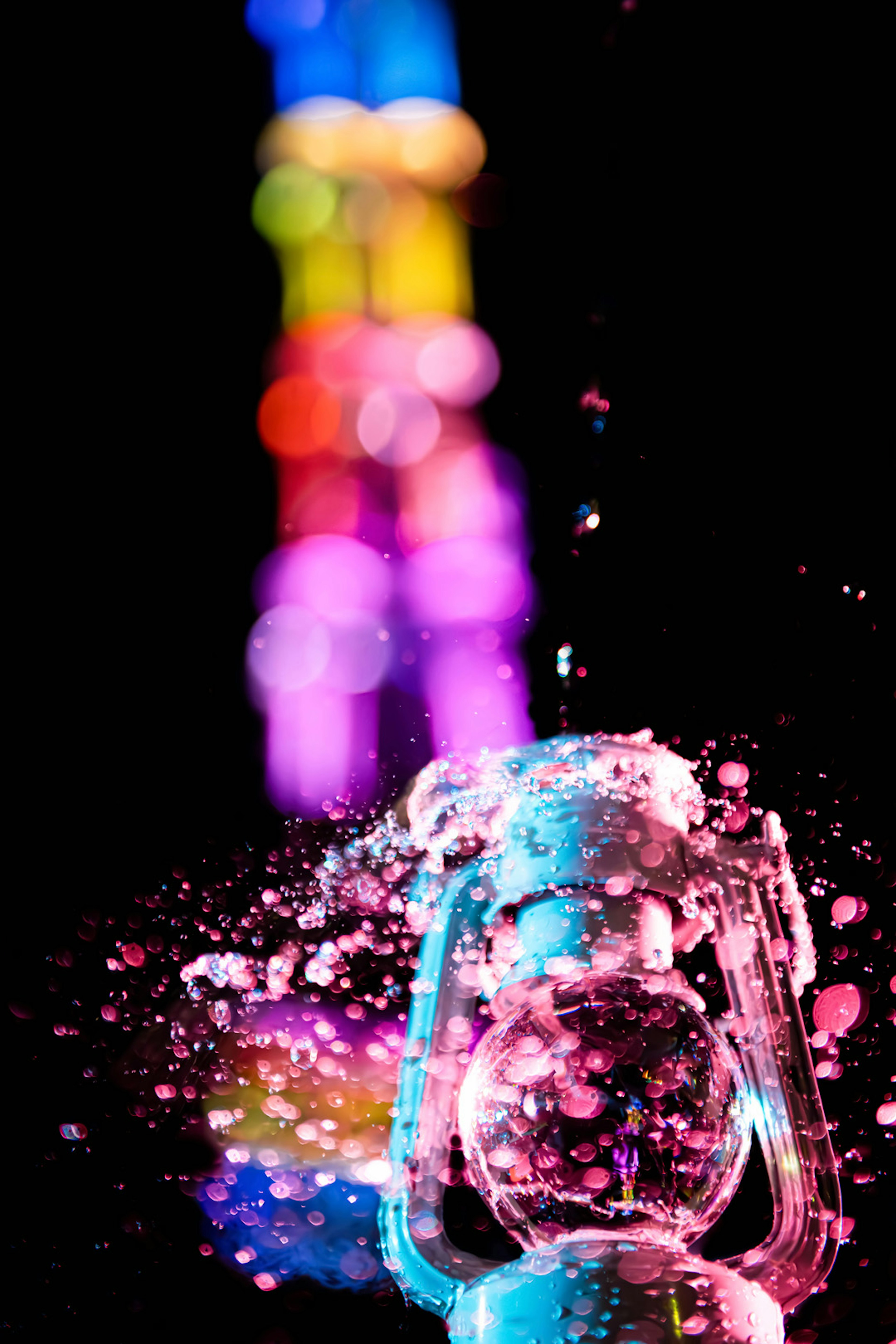 Clear object with splashes of water against a colorful light background