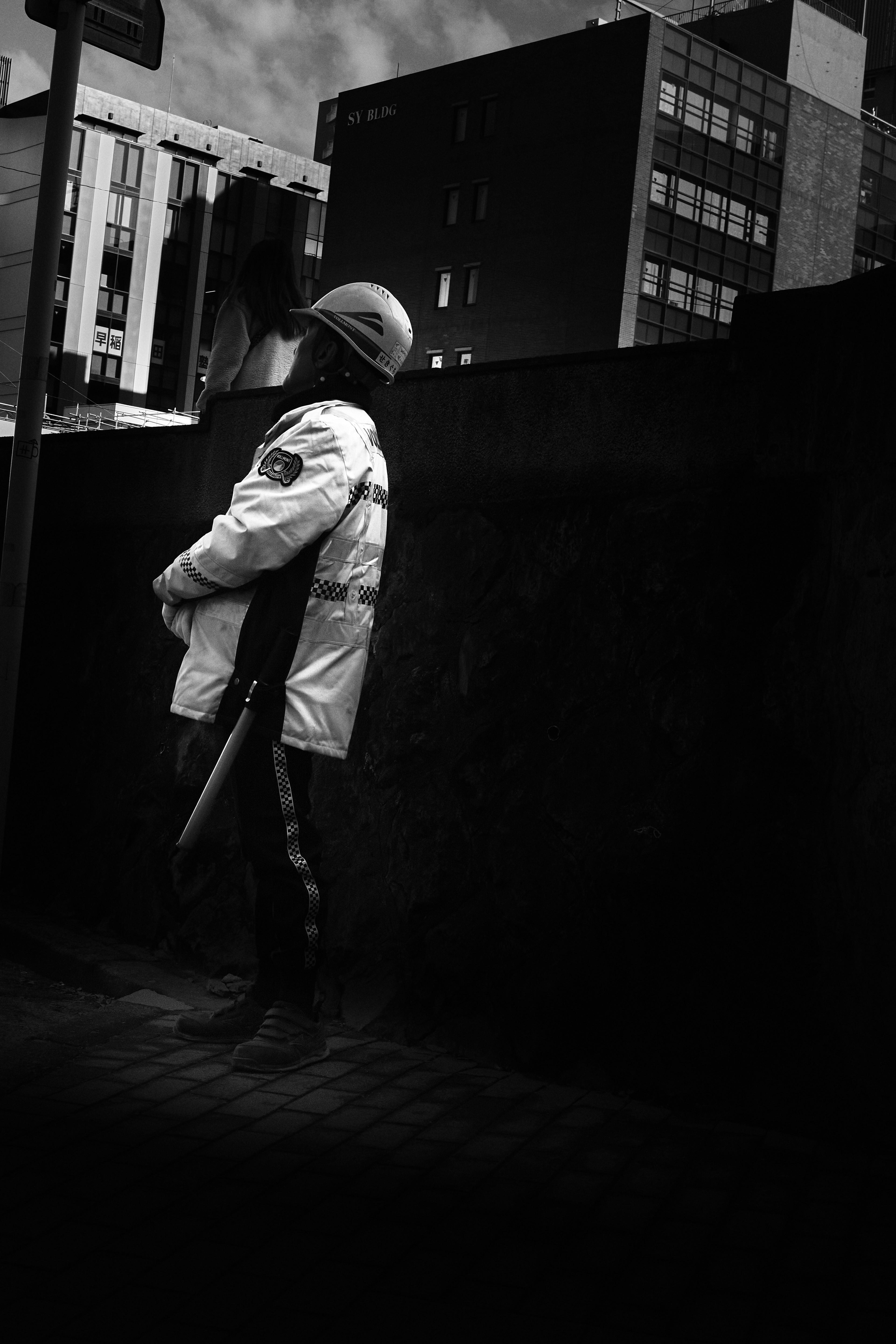 A police officer standing on a city street in a black and white setting