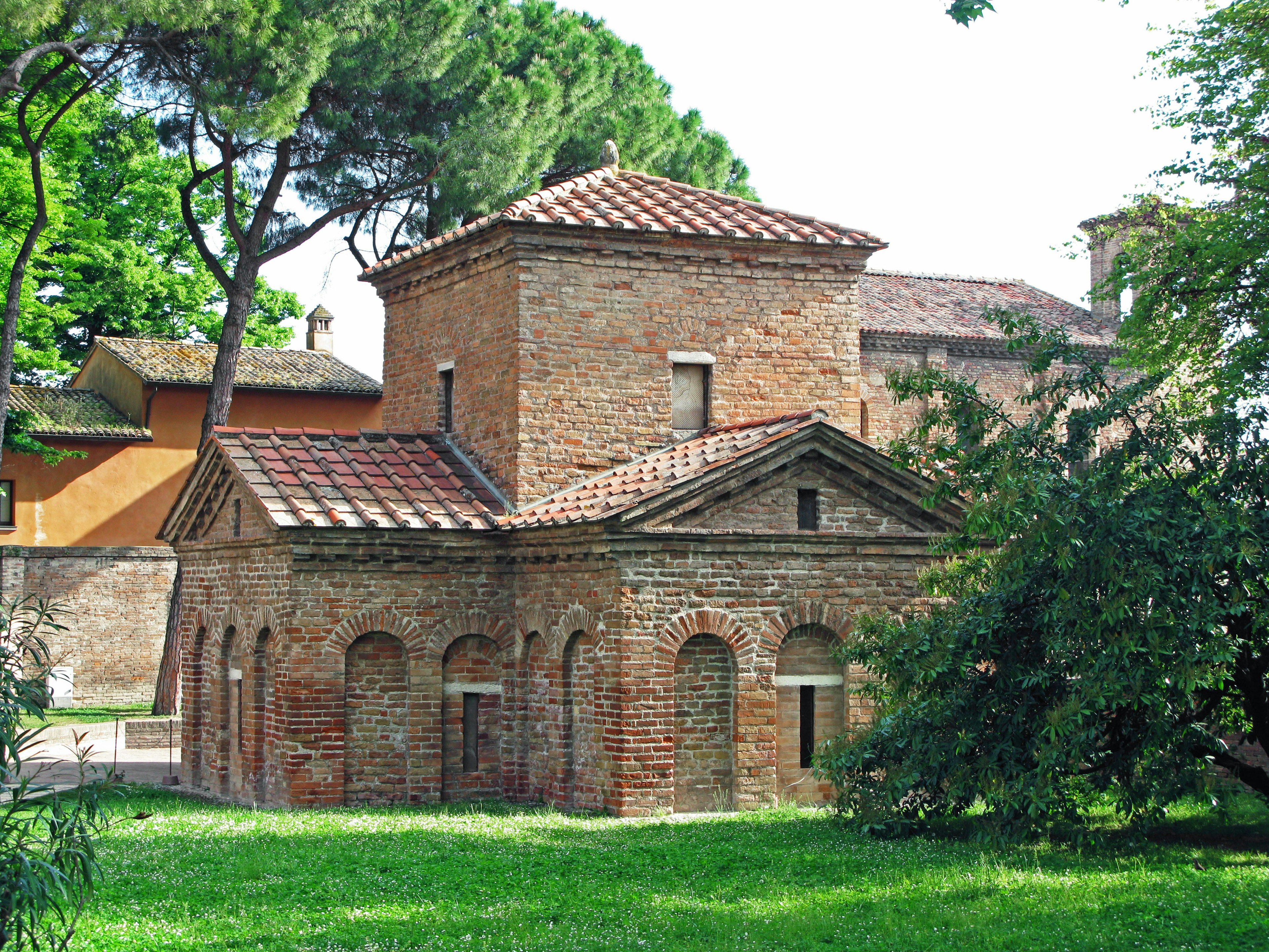 Antico edificio in mattoni circondato da vegetazione in un giardino