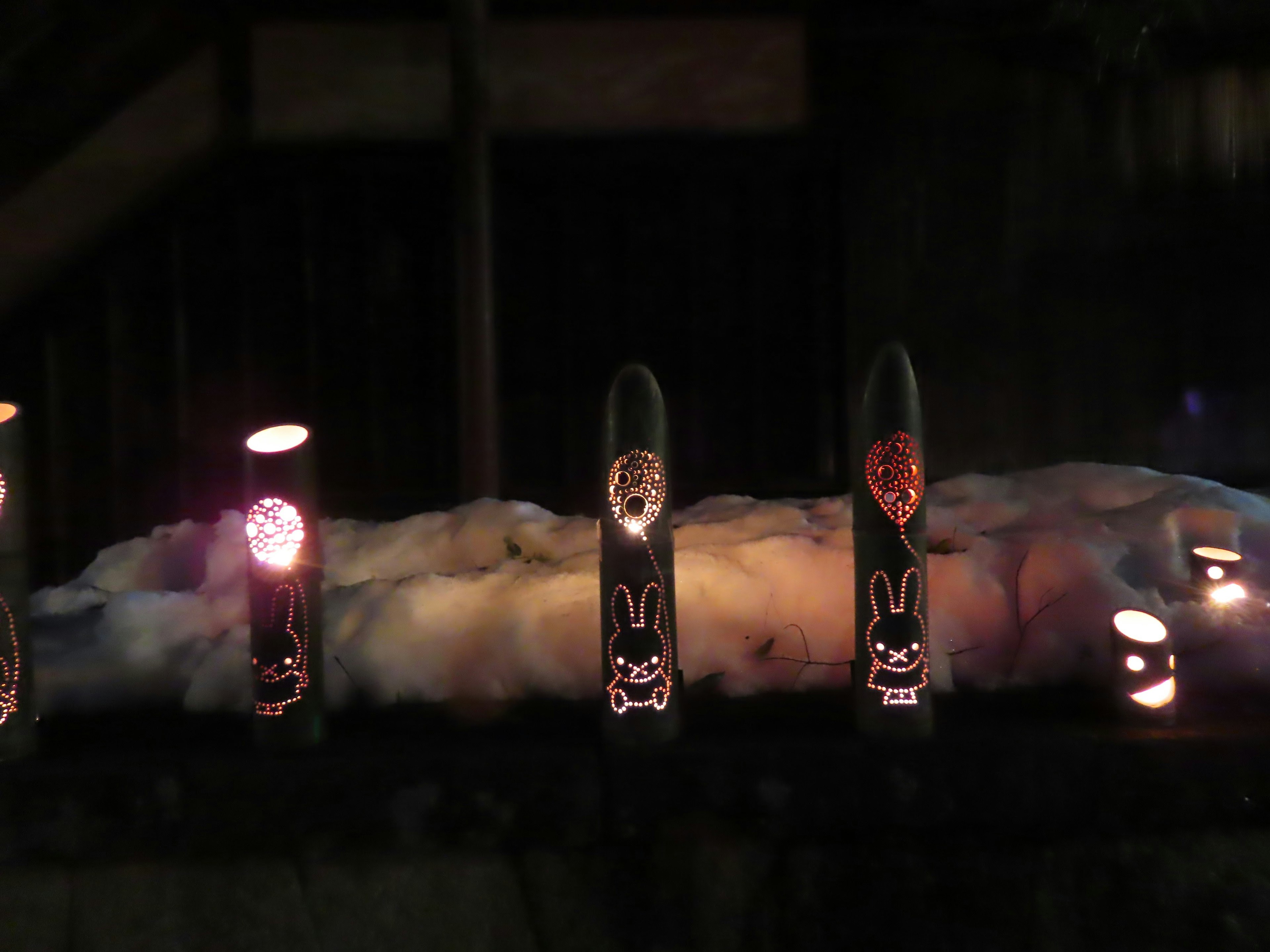 Black bamboo lanterns with rabbit designs illuminated at night