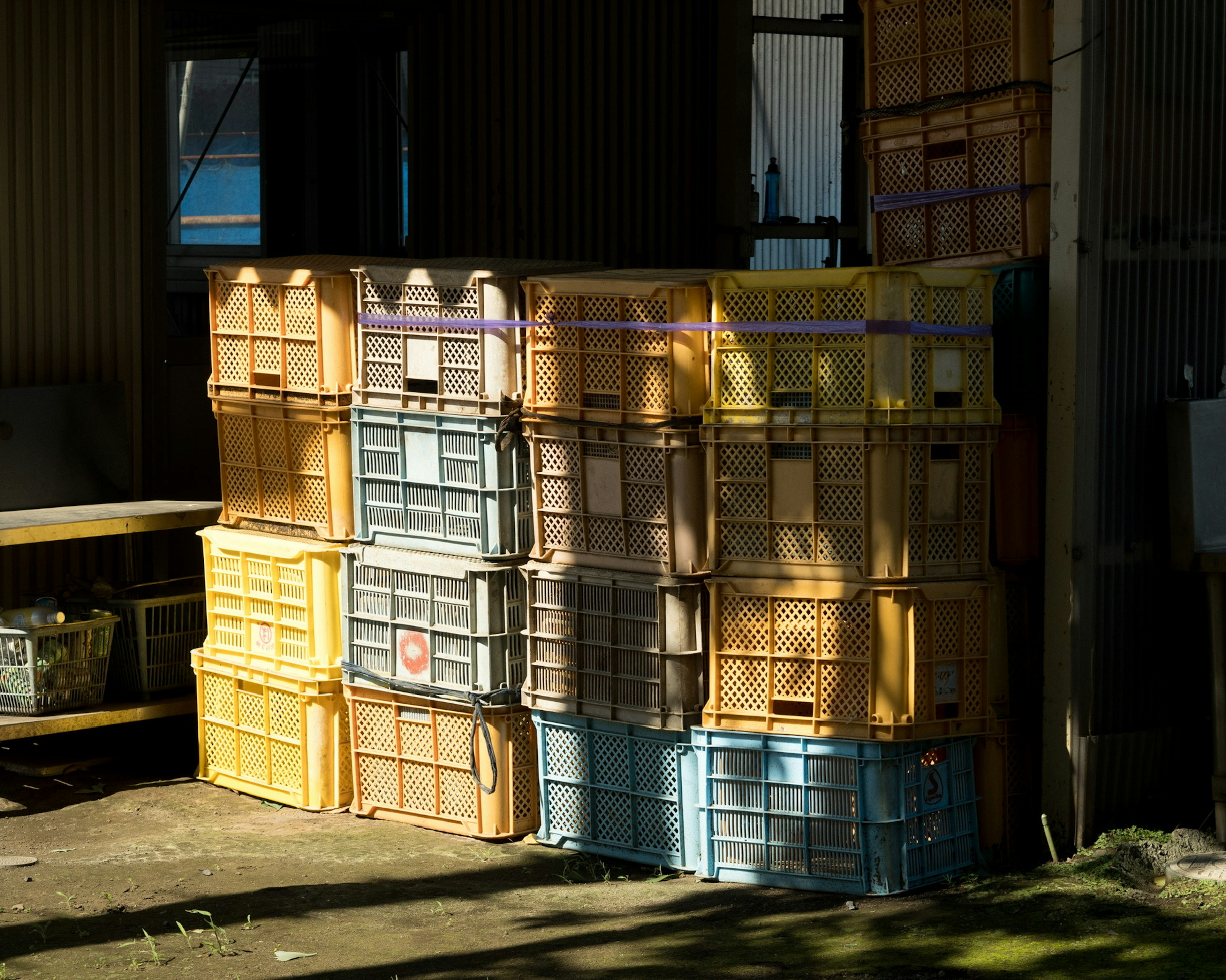 Colorful plastic containers stacked in a rustic setting