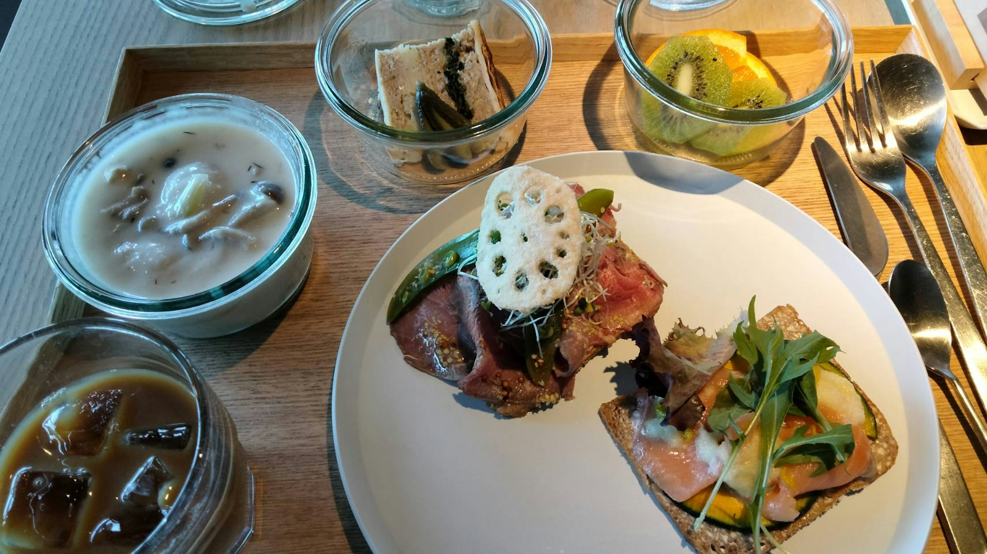 A plate with colorful dishes and jars of dessert arranged on a table