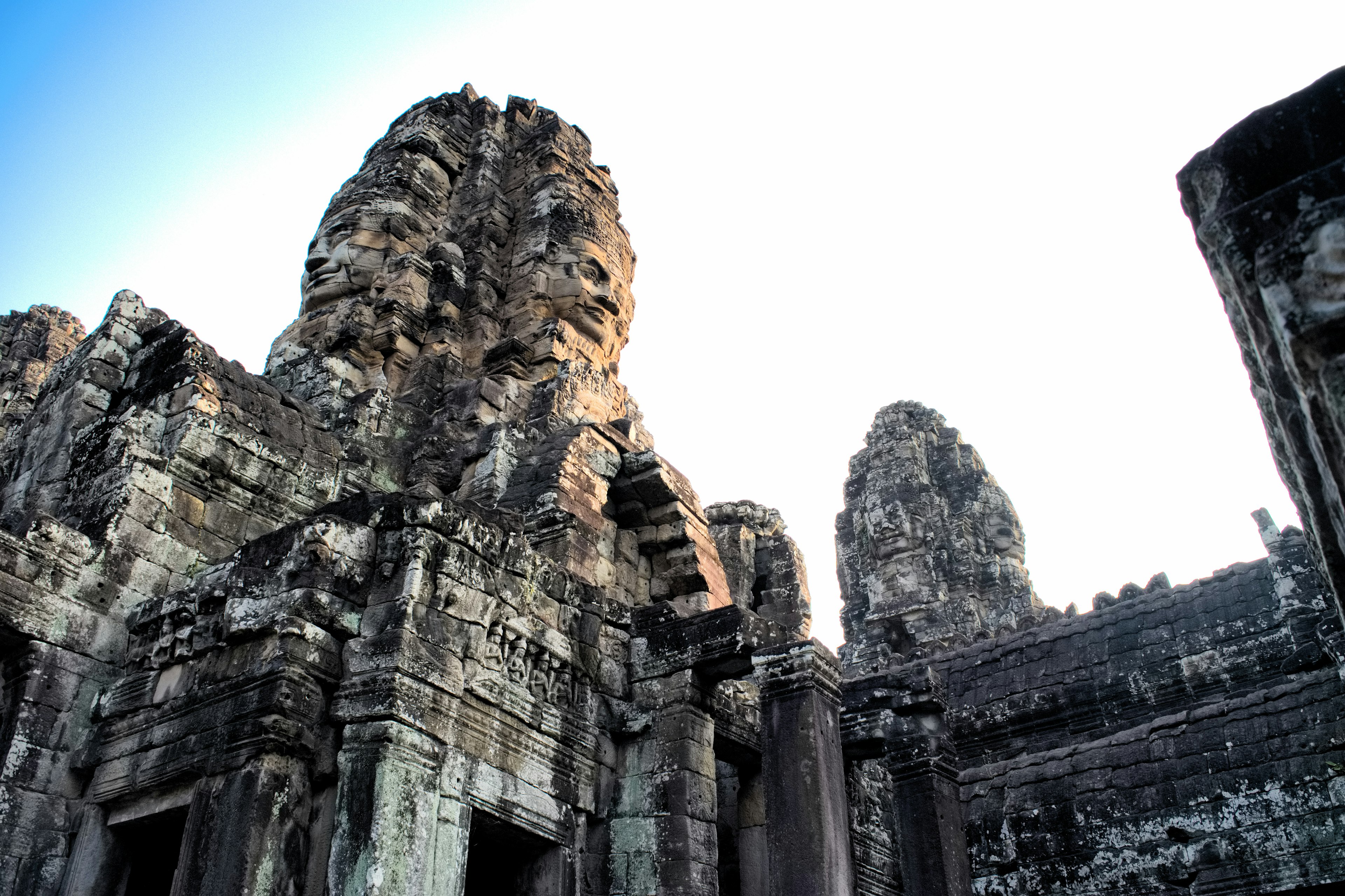 Riesige Gesichtsskulpturen im Bayon-Tempel in Angkor Wat mit antiken Ruinen