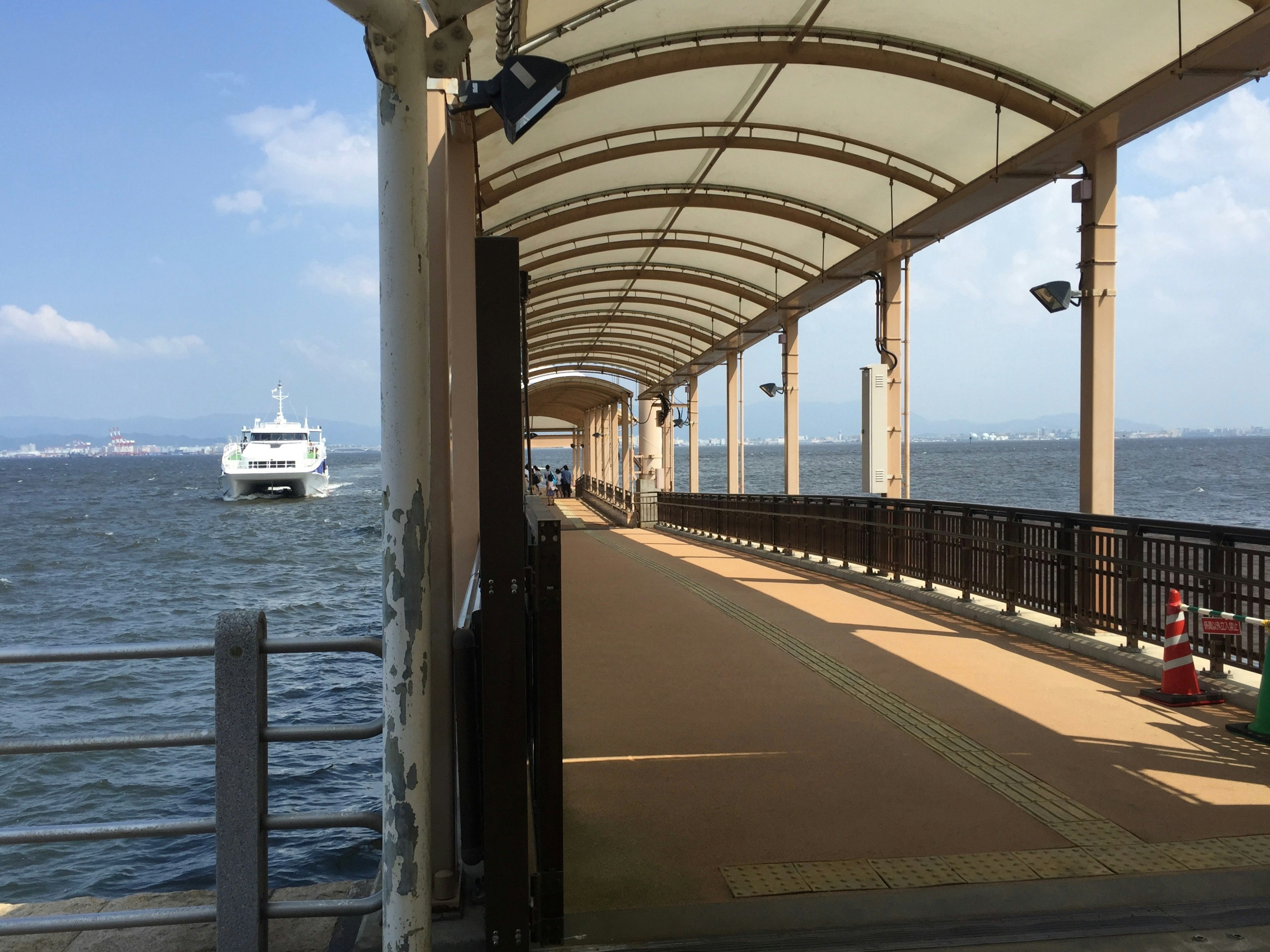 Vista de un paseo marítimo con un barco a lo lejos