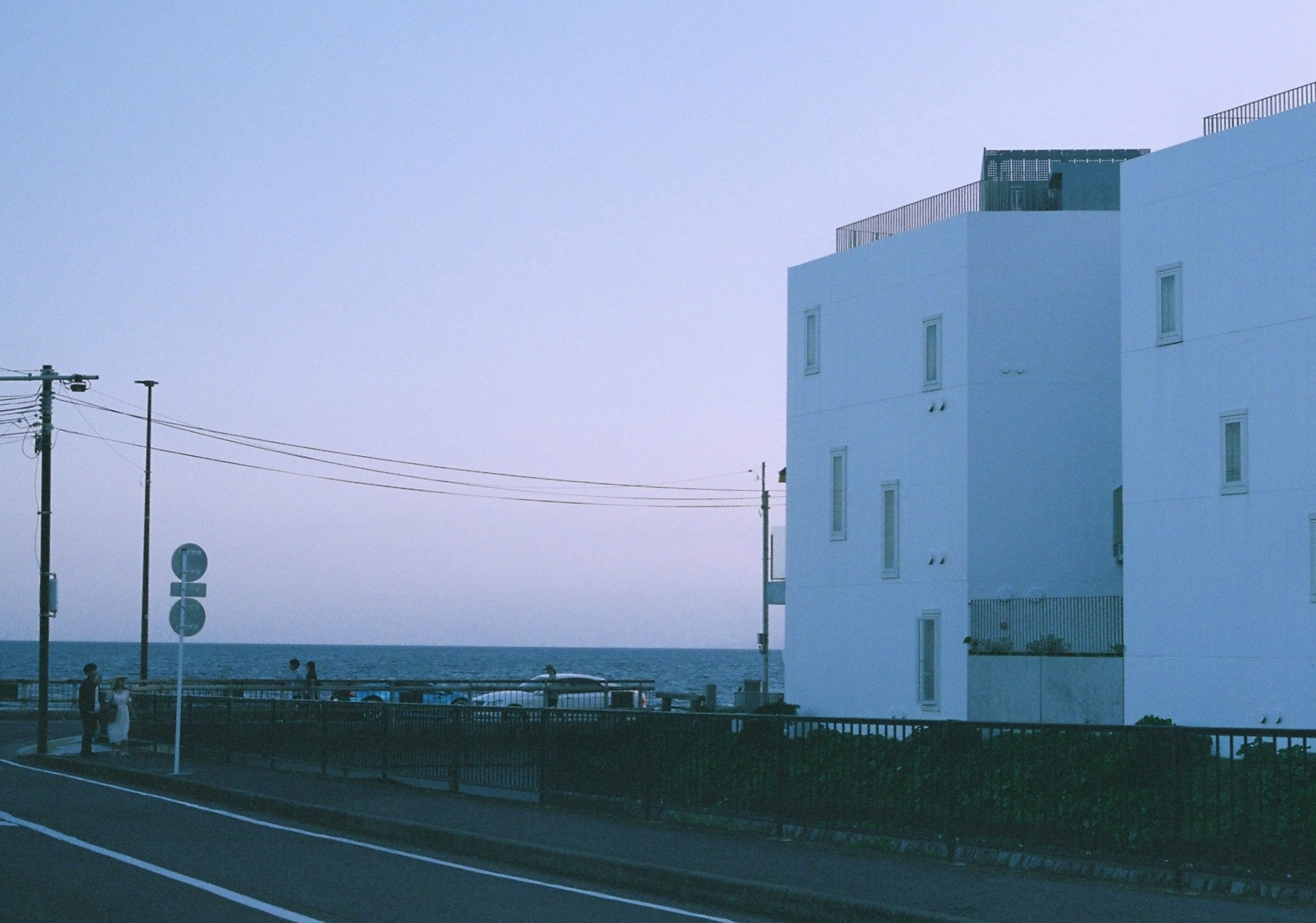 Vue pittoresque d'un bâtiment blanc au bord de l'océan et d'une route