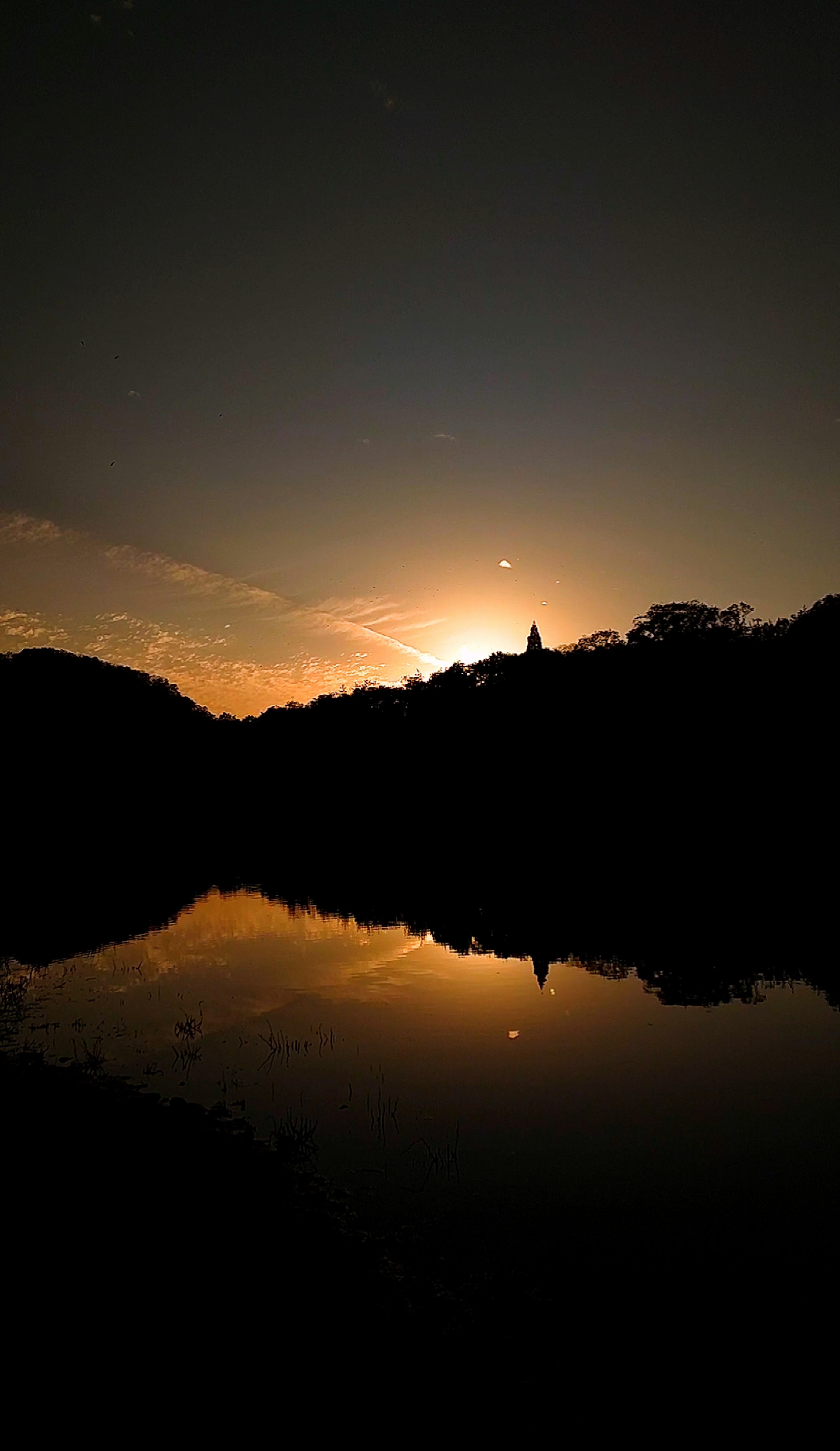 Senja di atas danau dengan siluet gunung