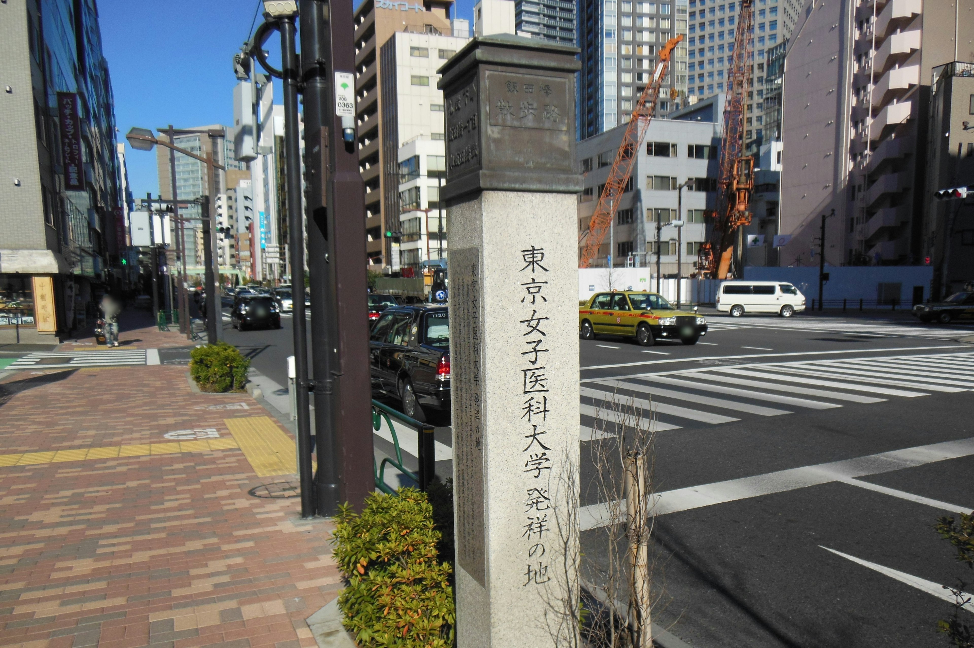 Vista cittadina con un'insegna per l'Università cristiana femminile di Tokyo