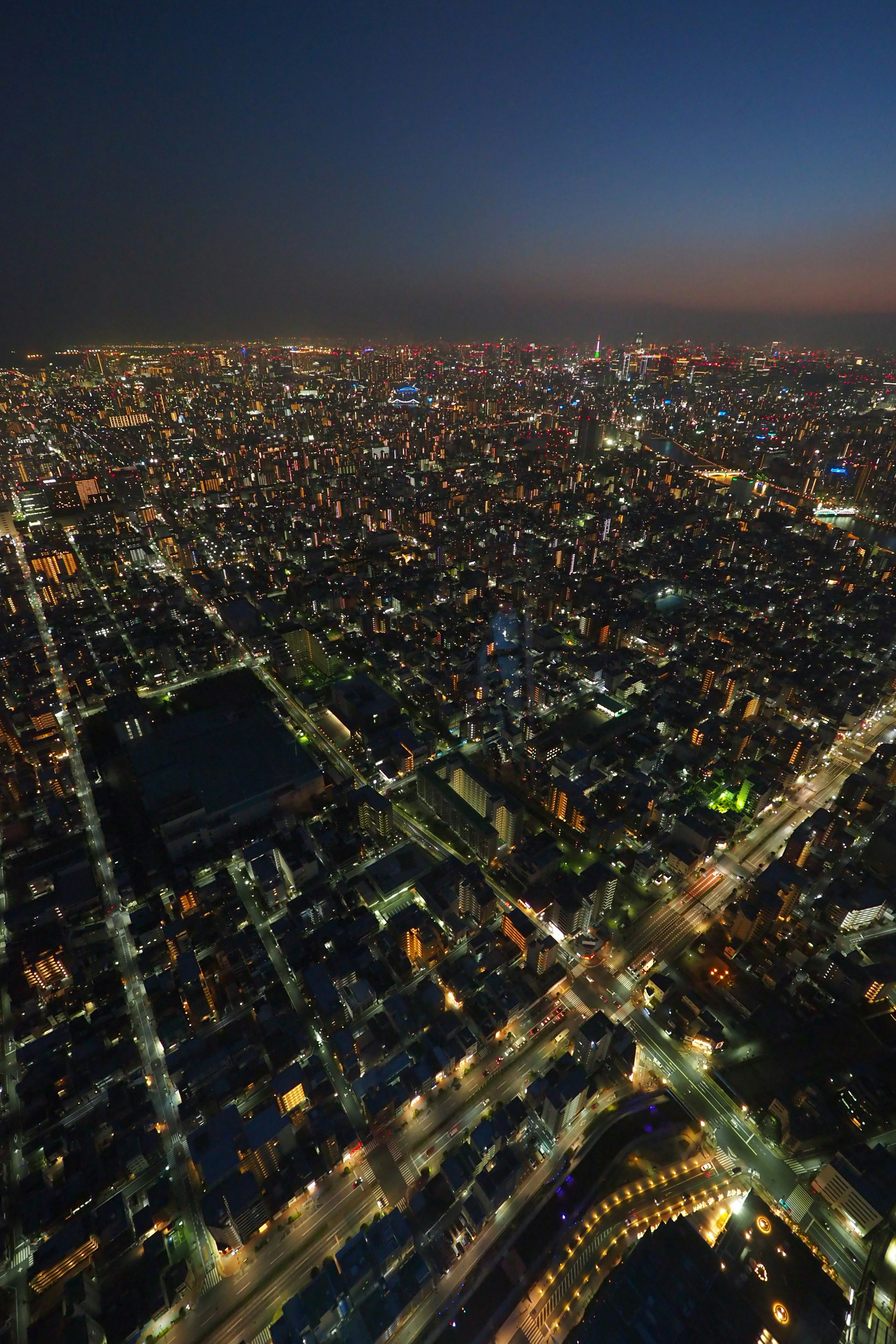 夜间城市的航拍视图，展示了灯光照亮的建筑和街道