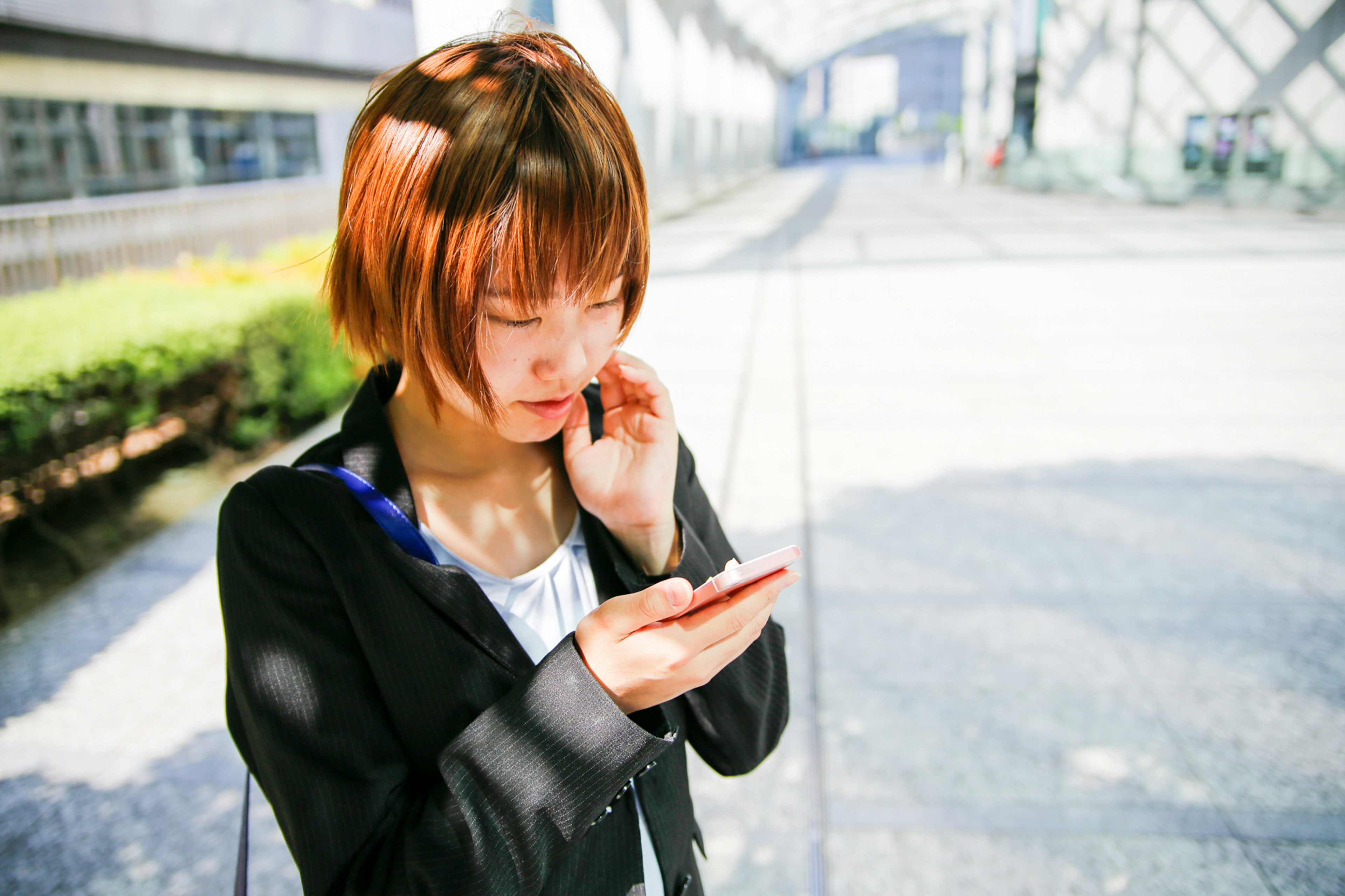 Eine Frau im Businessanzug schaut auf ihr Smartphone