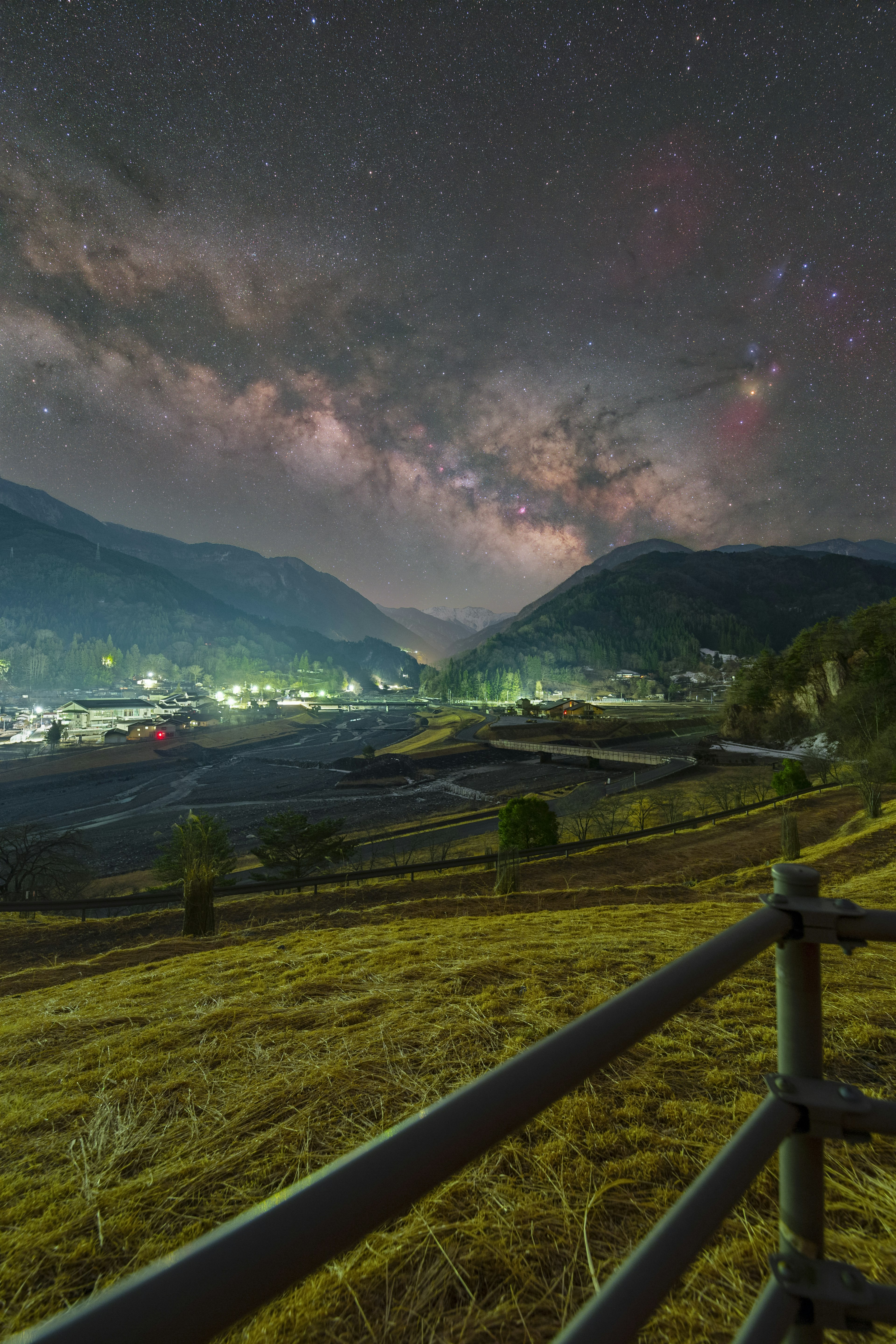 星空と山々を背景にした静かな村の夜景