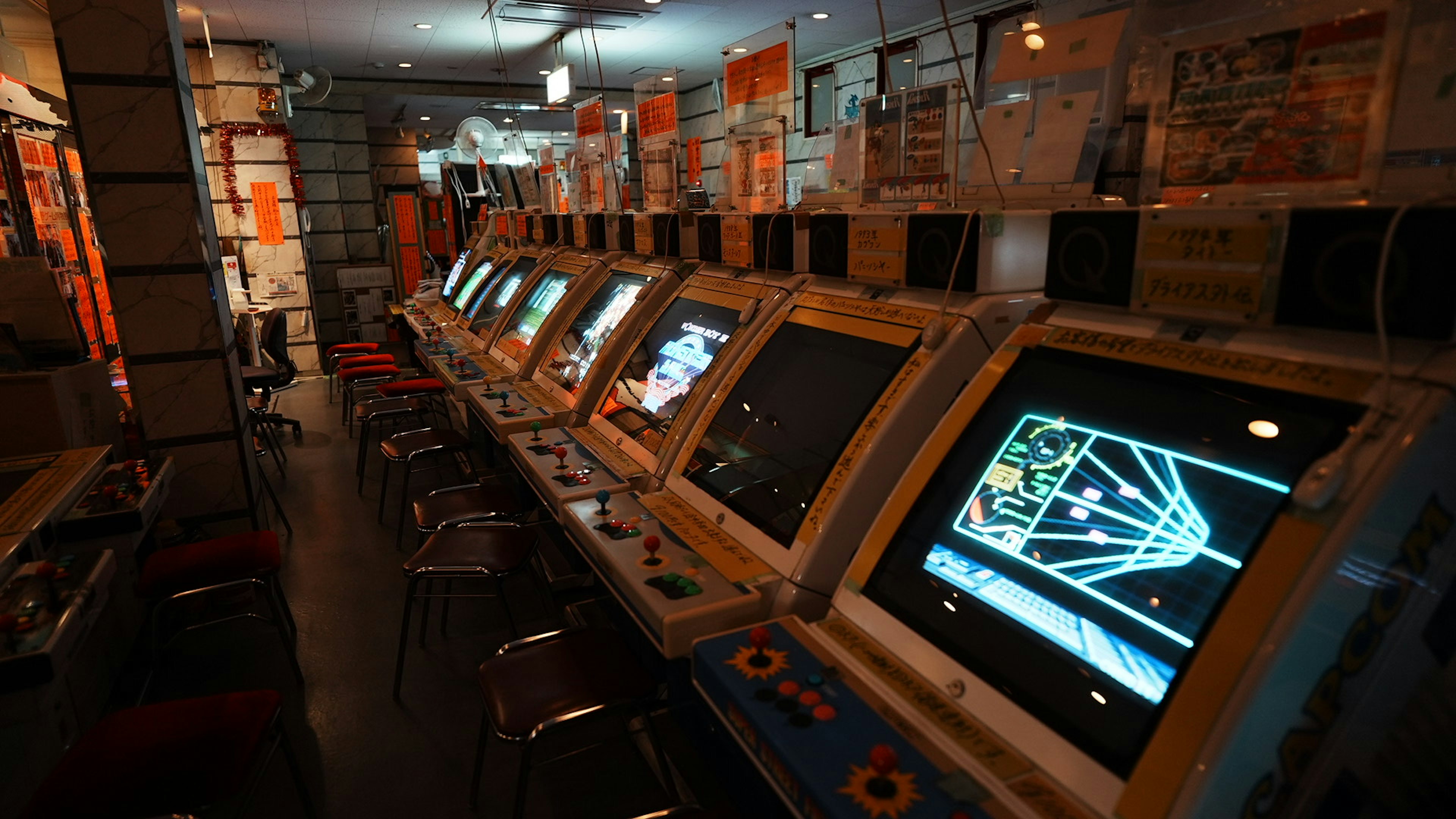 Vista interior de una sala de juegos con filas de máquinas de arcade