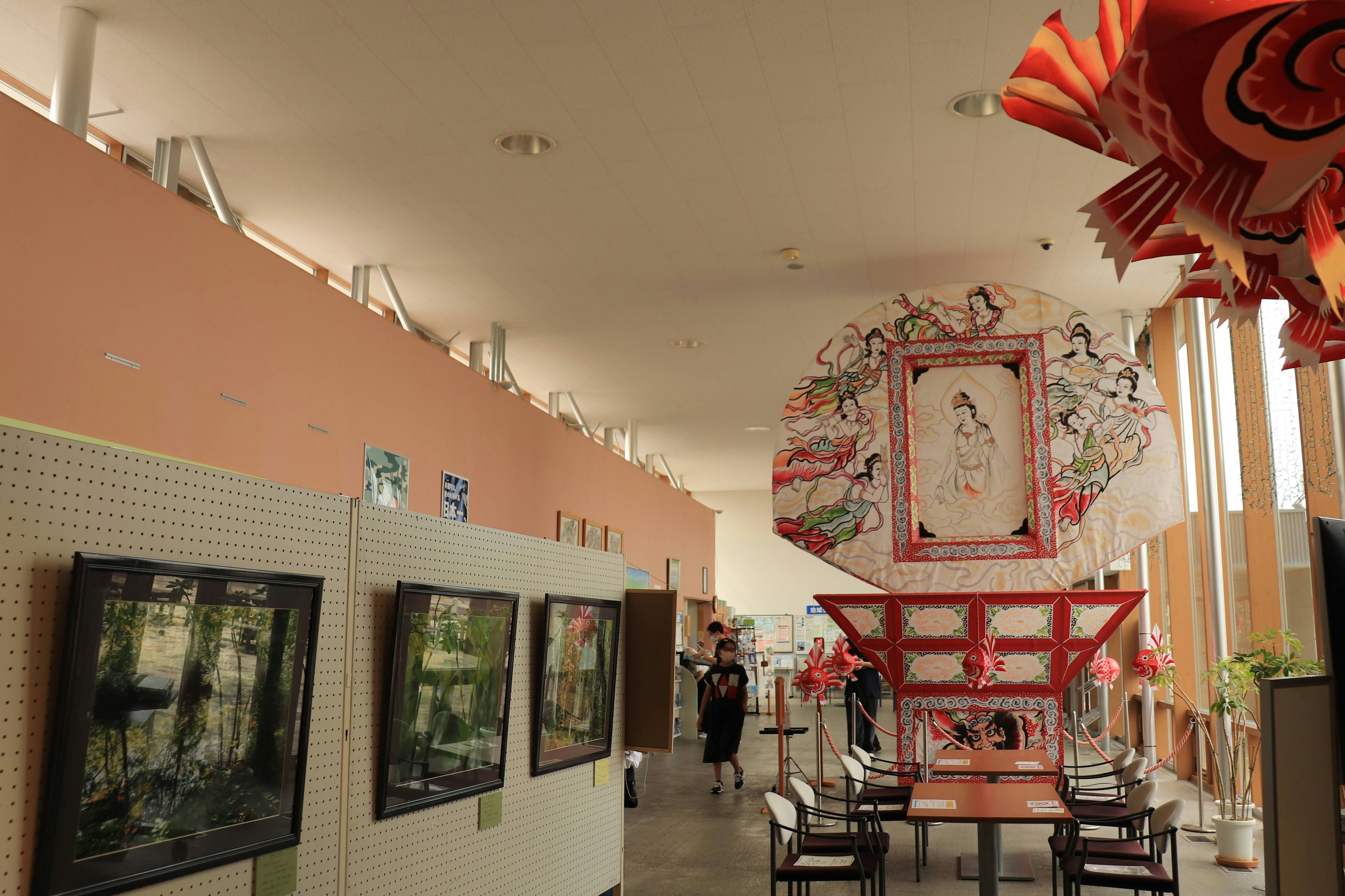 Interior of an art gallery featuring paintings and a large decorative piece