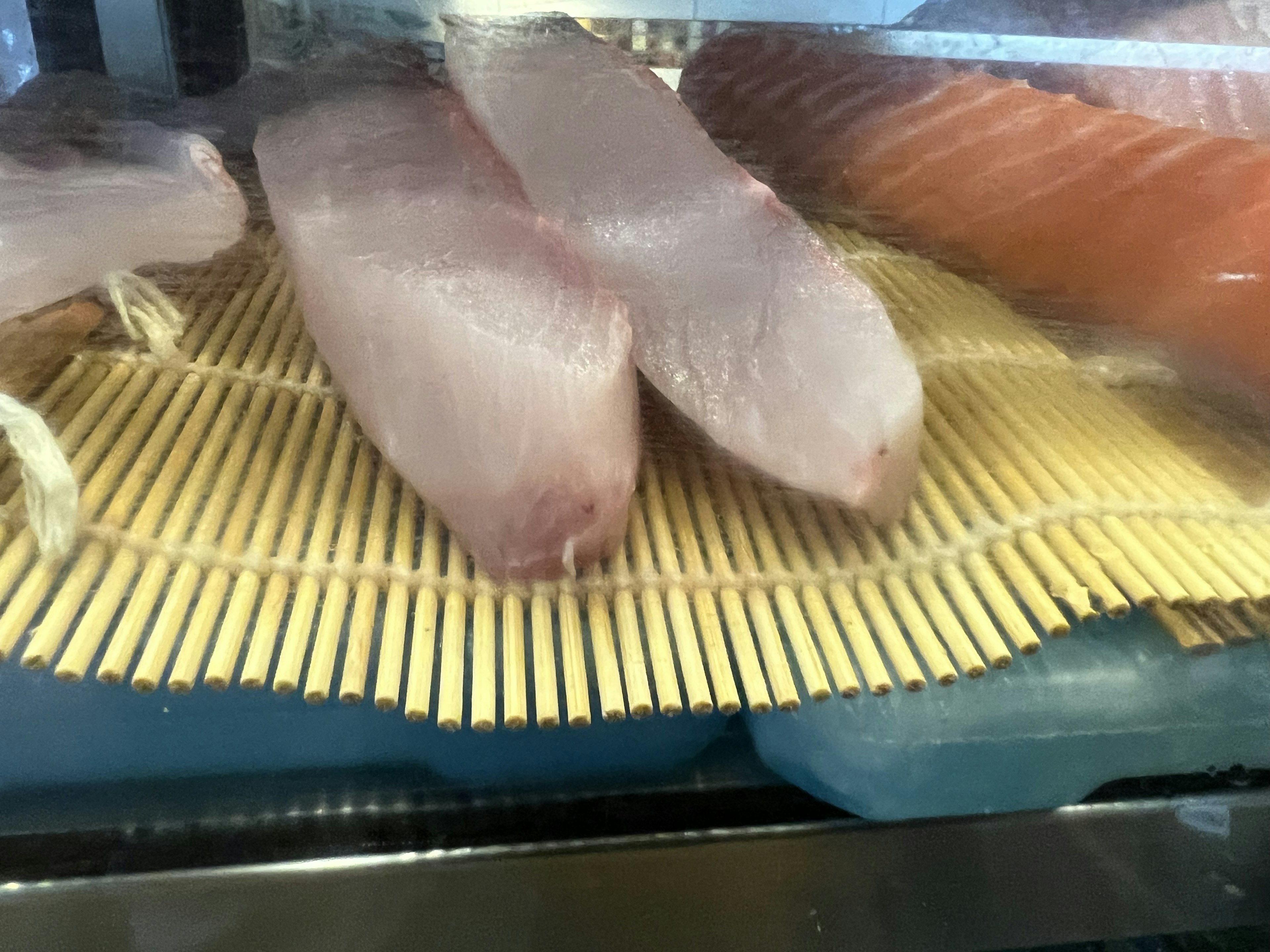 Fresh fish fillets placed on a bamboo mat