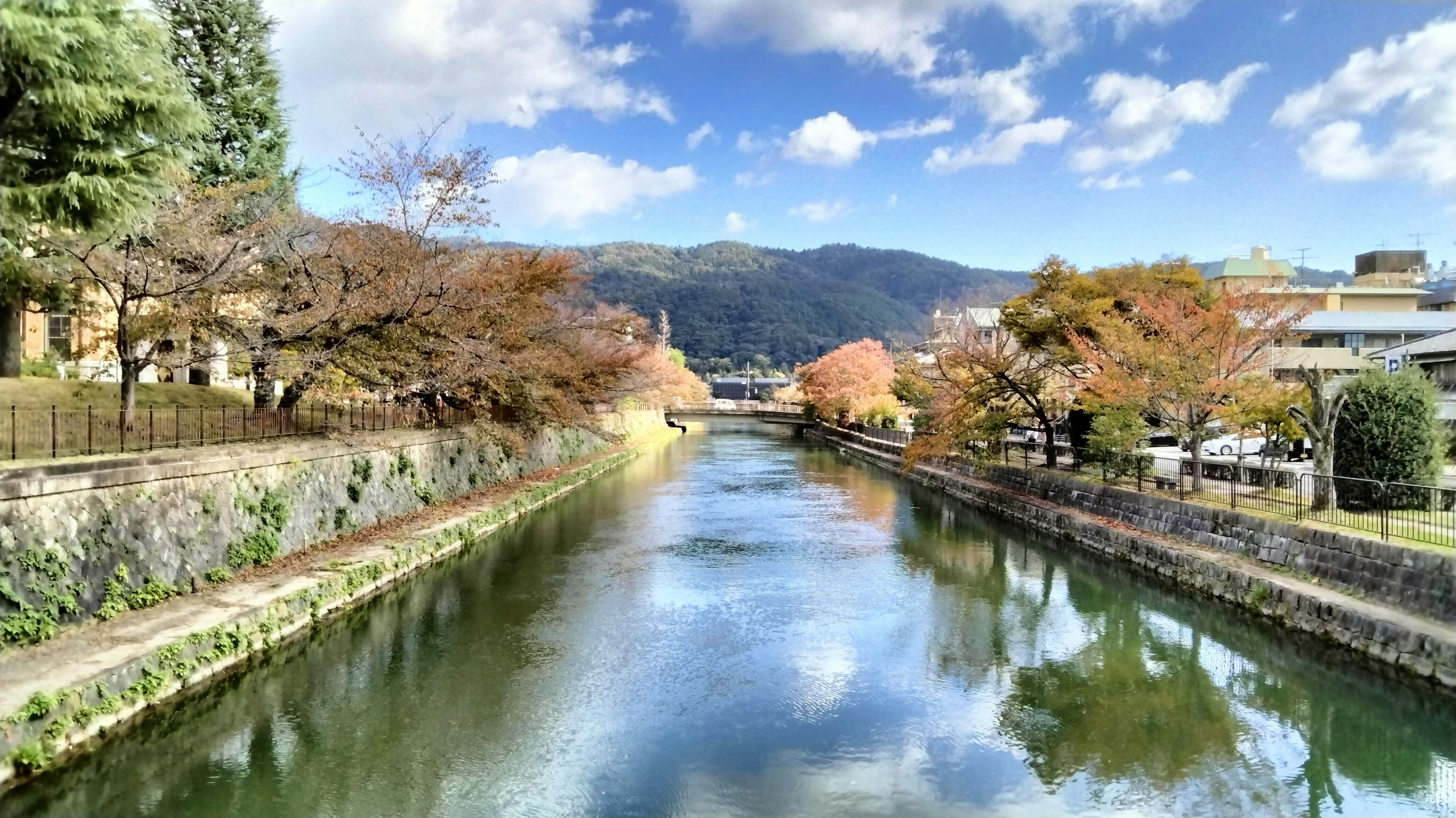 Rivière sereine reflétant le feuillage d'automne et le ciel bleu