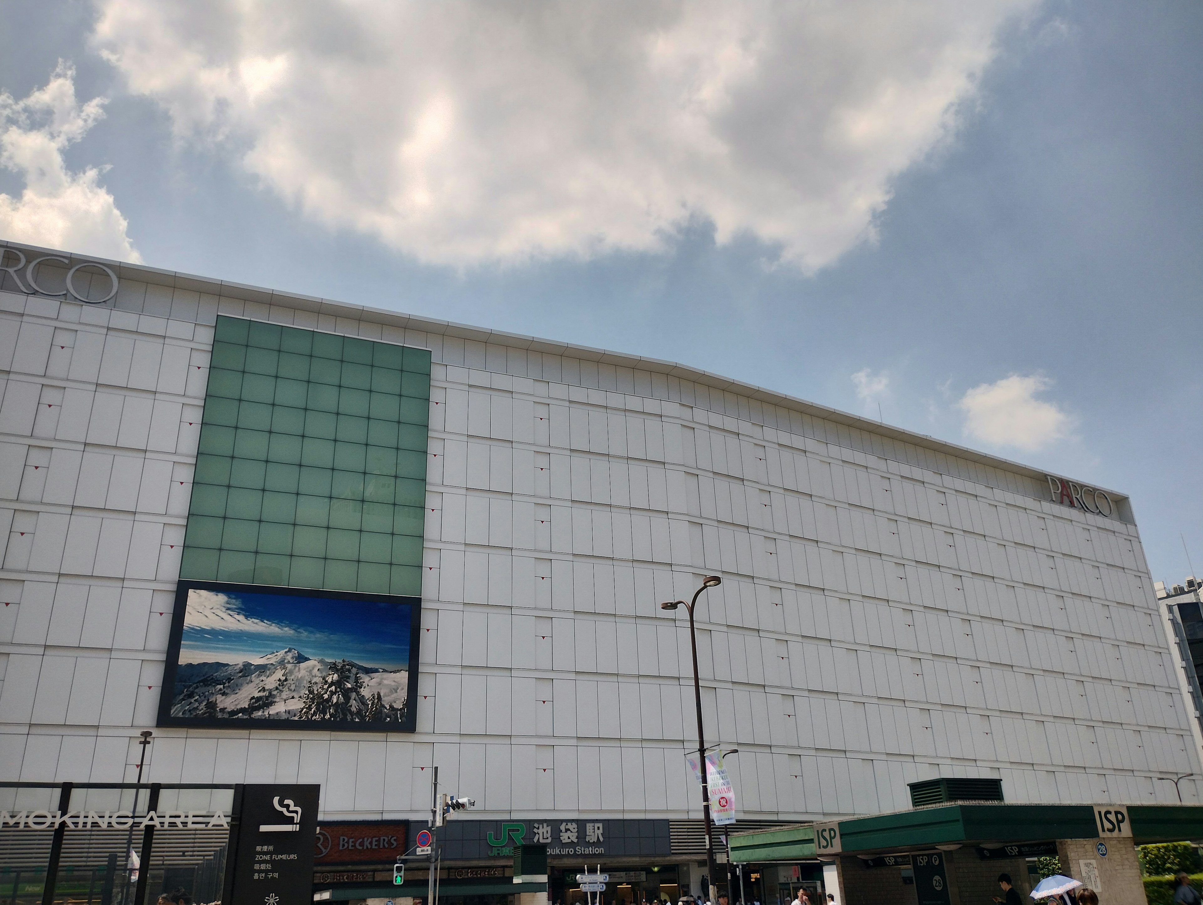 Edificio moderno con fachada blanca y panel verde con publicidad exterior