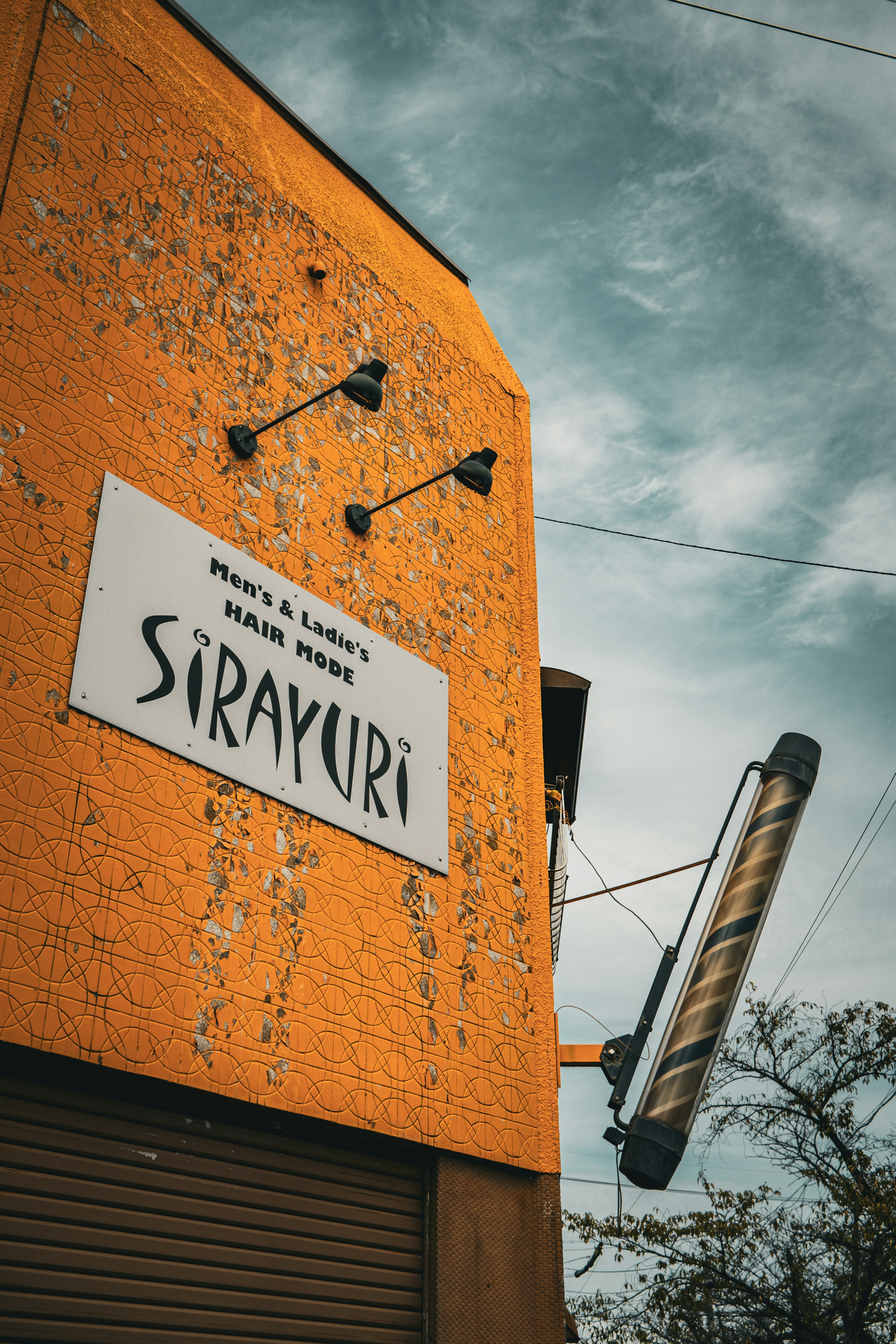 Exterior of a restaurant with an orange wall and a white sign